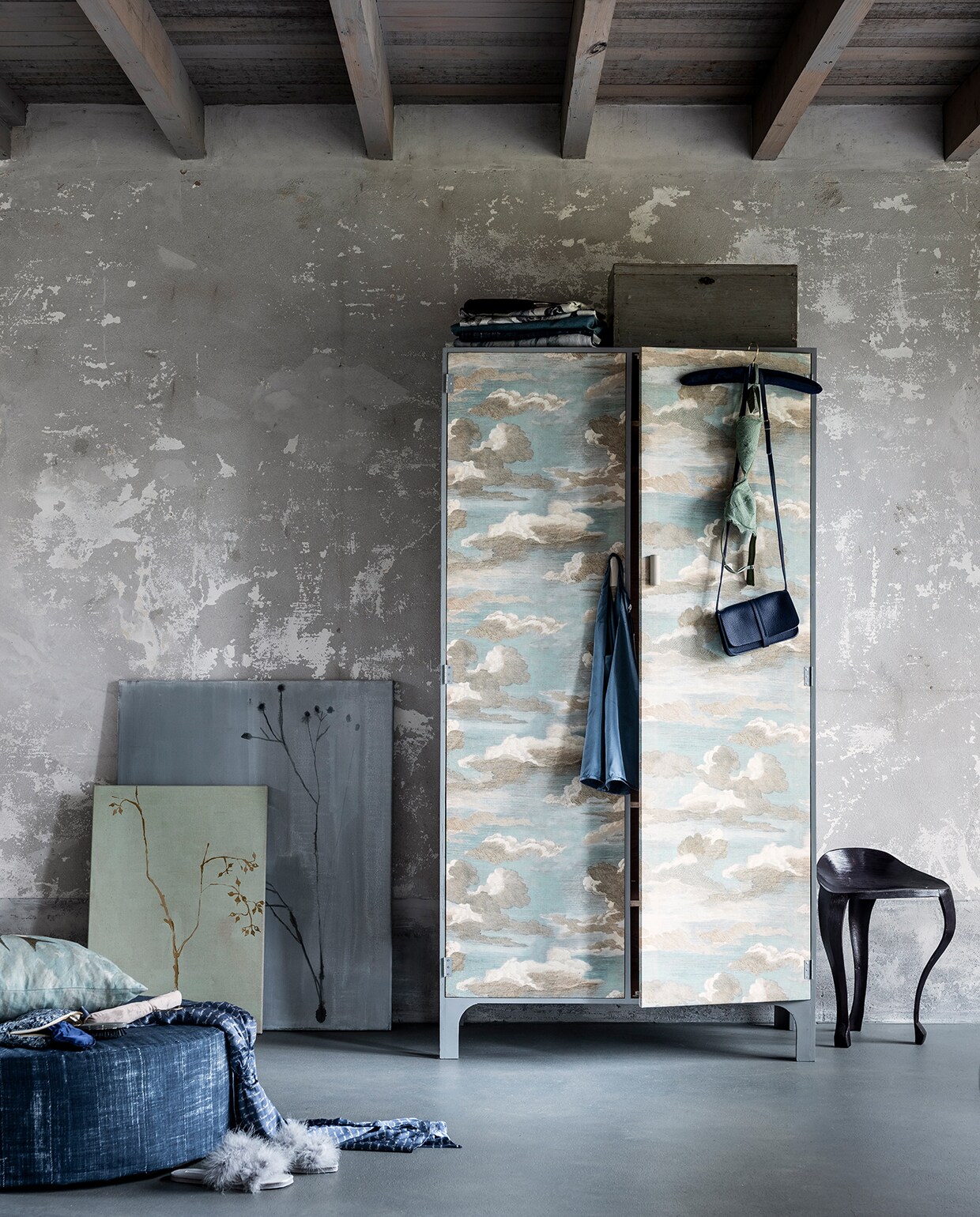Kast, 170 x 90 cm (hxb), (com-anders.nl). Verf in kleur Manor House Gray (farrow-ball.com). Kussen van stof Chimney swallows sky blue van Designers Guild x John Derian (wva.nl). Schilderijen, (maartjevandennoort.nl). Poef bekleed met stof Niek (kwantum.nl). Blauw leren tasje (klevering.nl). Zwarte driepootkruk (maisonnl.com). Overige privébezit. vtwonen 03-2020 stof verf behang special | styling Danielle Verheul | fotografie Sjoerd Eickmans