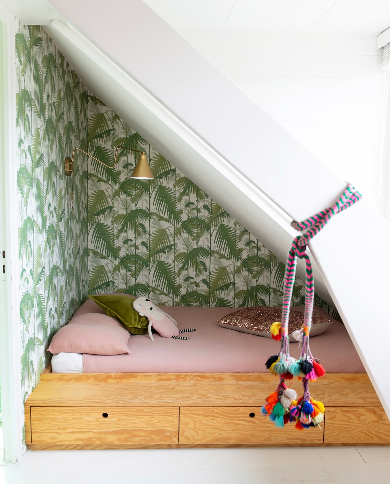 Op de kamer van Maggie een wandrek met bureau van String. Print van Parijs door Famille Summerbelle, Batgirl-print van Mini &amp; Maximus, stoel van een rommelmarkt. Links in het rek modernistisch poppenhuis Villa Sibis van Sirch. Poppetjes van Petit Depot, karpet uit Marokko, lamp House Doctor, kledingkast vintage.Herkomst overig onbekend. vtwonen 09-2021 | styling Jeske Weel | fotografie Caroline Coehorst | tekst Chris Muyres