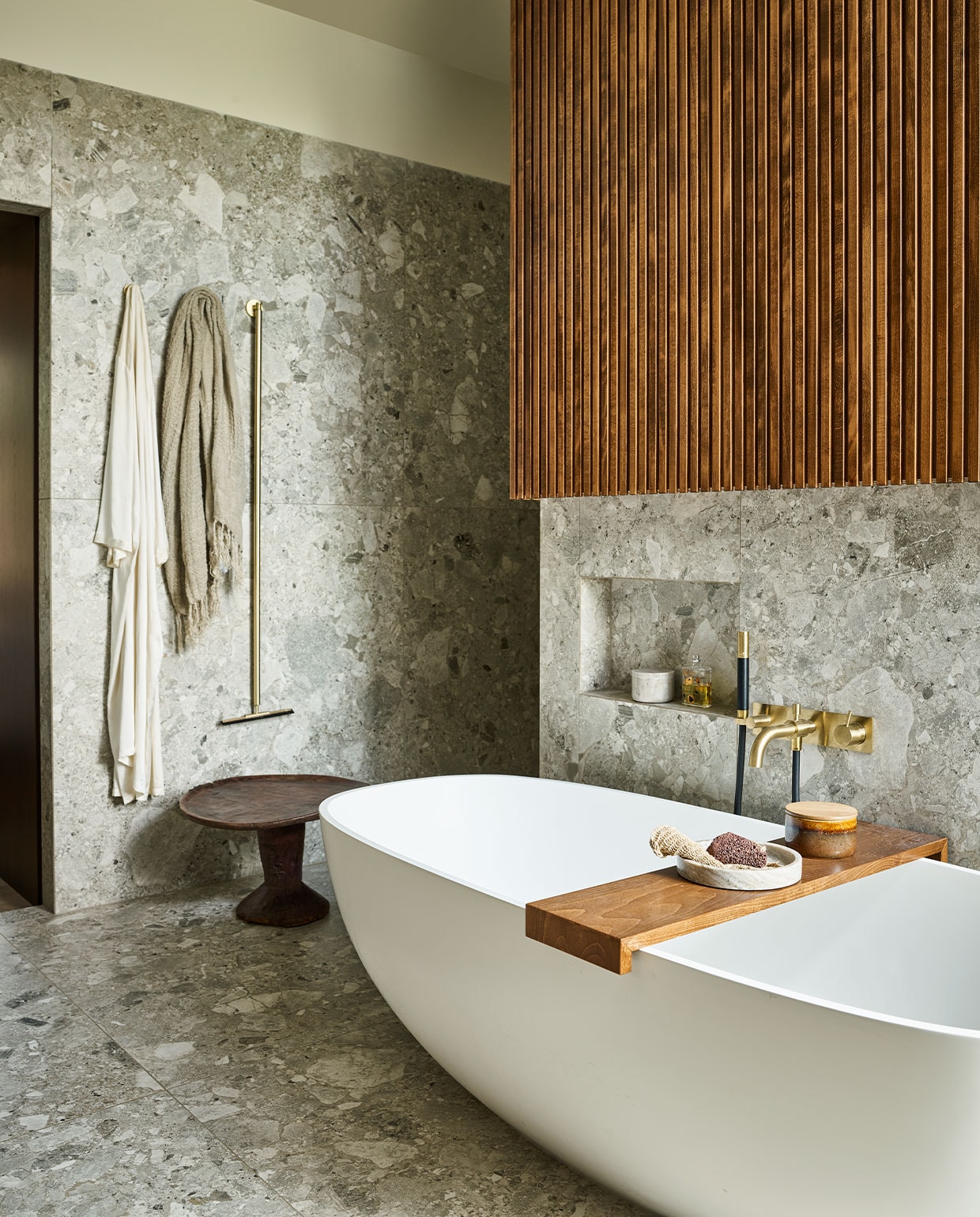 Vrijstaand bad Dado Quartz, prijs op aanvraag, grote tegels Light Grey Composiet uit de vtwonen-collectie, 120×120 cm, per m2 € 80,75, messing badmengkraan Hotbath Cobber CB026 met handdouche, vanaf € 798,60 (tonscholten.nl). Linnen badlaken € 80,50, marmeren schaal, € 69,95, marmeren potje, € 69,95 (nordal.eu). Houten bijzettafel Jimma, € 335,- (couleurlocale.eu). vtwonen 09-2021 | styling Cleo Scheulderman | fotografie Jeroen van der Spek