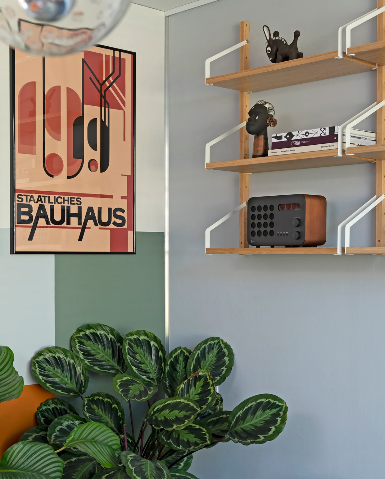 Posters pstr.studio, lijsten Yourdecoration. Muren leemgroen en zinkgrijs Karwei, Indian spice Flexa. Plankjes Svalnäs Ikea. Met daarop: radio Eames, houten figuren Kay Bojesen vtwonen 09-2021 | styling Sharon Roest | fotografie Caroline Martinot | tekst Sara Madou