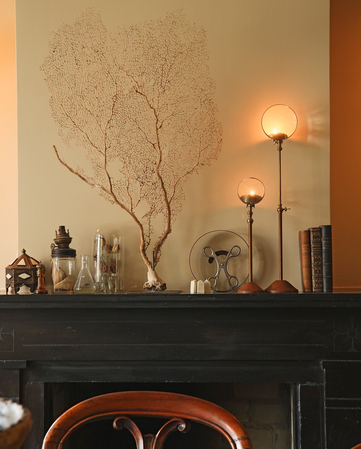 De marmeren haard is een podium voor natuurvondsten en unieke stukken zoals de lampen met vergrootglaasjes (niet meer te koop). vtwonen 09-2021 | Styling Liza Wassenaar | Fotografie Irisdorine | Tekst Jack Meijers