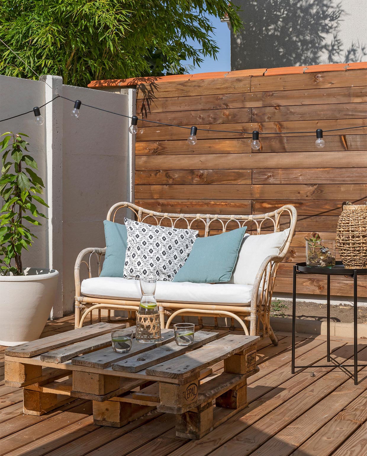 Rotan bank Mastholmen en bijzettafel Gladom Ikea. Tafel gemaakt van pallets. Overig onbekend. vtwonen special zomerhuizen 07-2021 | Productie en tekst Anne-Catherine Scoffoni | Fotografie Pauline Legoff