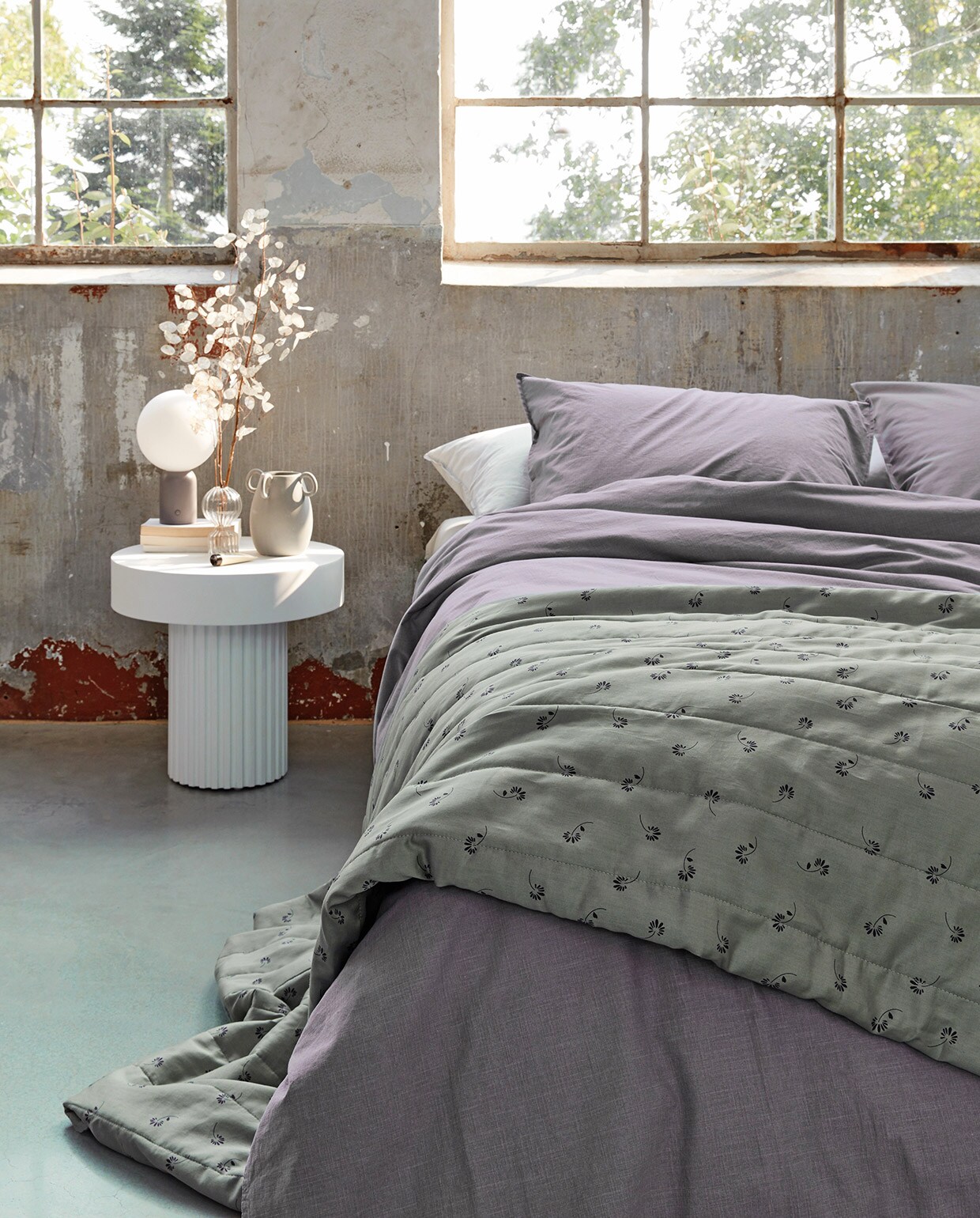 Katoenen dekbedovertrek Natural Stone in kleur lila, 140×200/220 cm, 200×200/220 cm en 240×200/220 cm (inclusief kussenslopen). Ook verkrijgbaar in kleur antraciet, donkergroen en terra. Op het bed katoenen Pattern quilt in kleur donkergroen (uni aan de binnenkant), verkrijgbaar in 180×250 cm en 260×250 cm. M.m.v. vtwonen.nl (nachtlamp van Bolia), loods5.nl/design (witte bijzettafel, glazen vaas). Overig privébezit. vtwonen 04-2021 | Productie Tanja Saarberg  | Styling danielle Verheul | Fotografie Richard Smit
