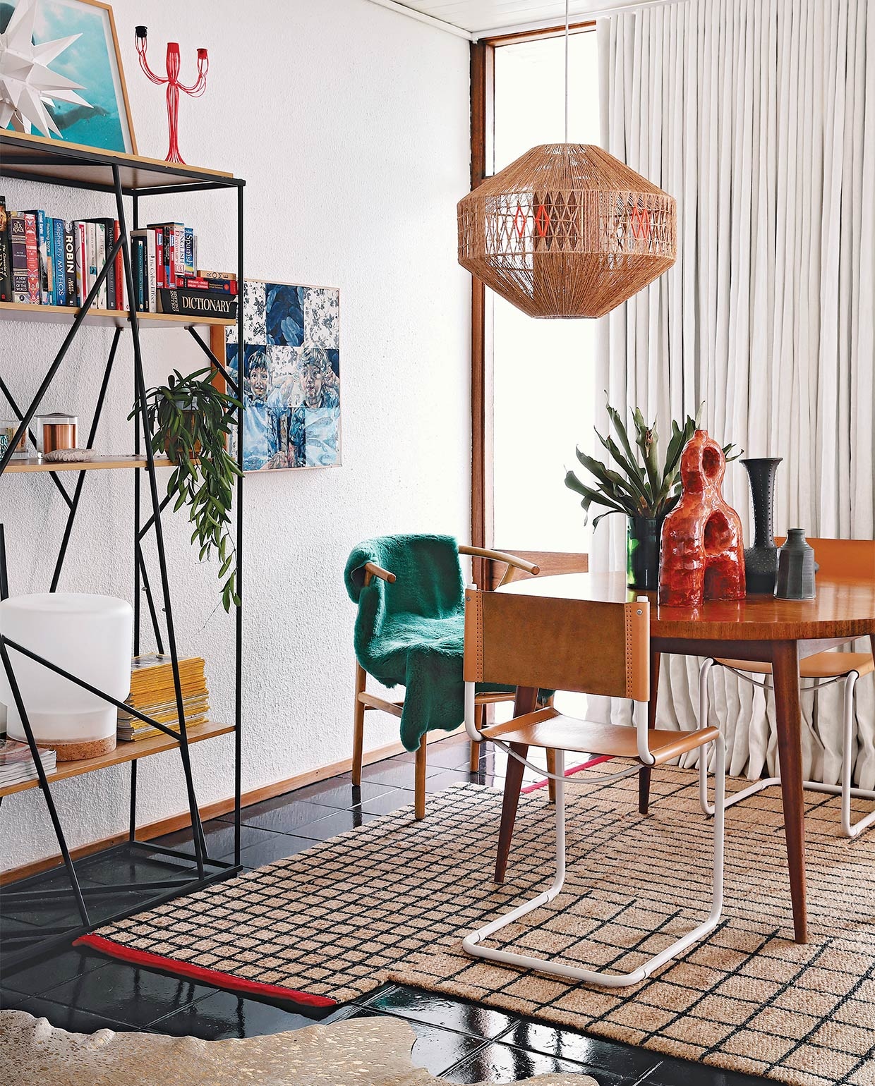 Vintage eettafel via Tonic Design. Stoel Wishbone Carl Hansen &amp; Son, overige stoelen Pezula Interiors. Groene schapenvacht Woodheads Cape Town. Rood, keramieken kunstwerk Ben Orkin, overige keramiek Anthony Shapiro. Hanglamp lokaal gekocht, die Kerryn versierde met oranje draad. Vloerkleed Ikea. Wandkast Mobelli. Witte ster Folha Plant Shop. Oranje kandelaar After Noah. Tafellamp Sinnerlig Ikea. Kunstwerk van Varenka Paschke. Overig onbekend. vtwonen special zomerhuizen 07-2021 | productie Luanne Toms/Frank feautures | fotografie Elsa Young