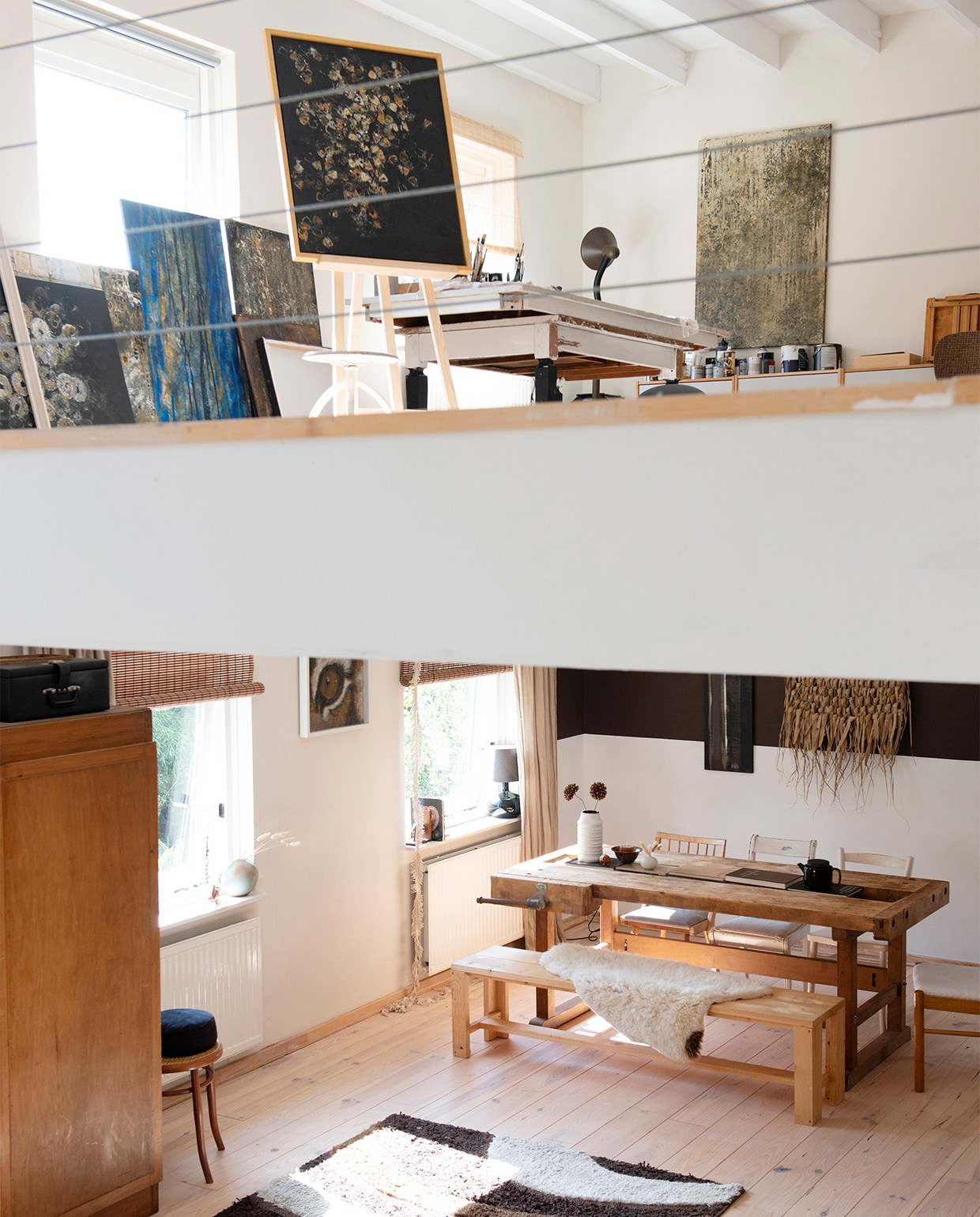 Het atelier op de split-level etage wordt van de vide gescheiden door een balustrade van staaldraad. vtwonen 08-2021 | productie de Binnenkijkers | styling Jeske Weel | fotografie Caroline Coehorst