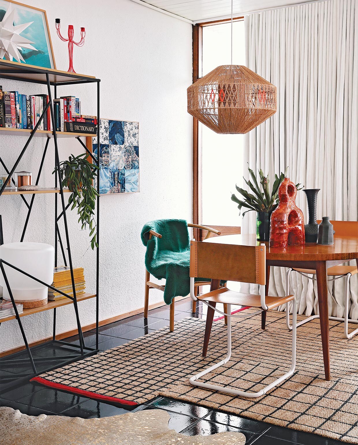 Vintage eettafel via Tonic Design. Stoel Wishbone Carl Hansen &amp; Son, overige stoelen Pezula Interiors. Groene schapenvacht Woodheads Cape Town. Rood, keramieken kunstwerk Ben Orkin, overige keramiek Anthony Shapiro. Hanglamp lokaal gekocht, die Kerryn versierde met oranje draad. Vloerkleed Ikea. Wandkast Mobelli. Witte ster Folha Plant Shop. Oranje kandelaar After Noah. Tafellamp Sinnerlig Ikea. Kunstwerk van Varenka Paschke. Overig onbekend. vtwonen special zomerhuizen 07-2021 | productie Luanne Toms/Frank feautures | fotografie Elsa Young