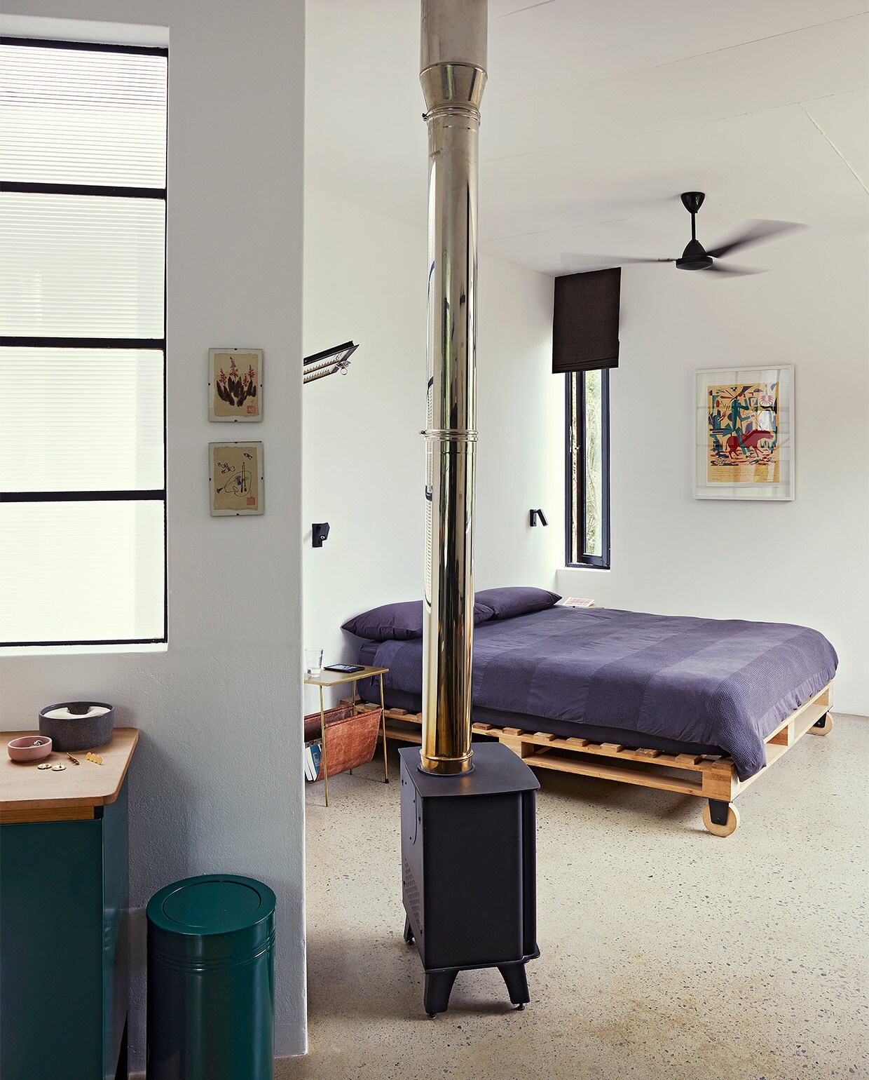 Prullenbak Pedersen + Lennard. Kachel Canature. Bed Weylandts, Beddengoed Country Road. Overig onbekend. vtwonen binnenkijk special 07-2021 | productie Livinginside/Bureaux | fotografie\nElsa Young