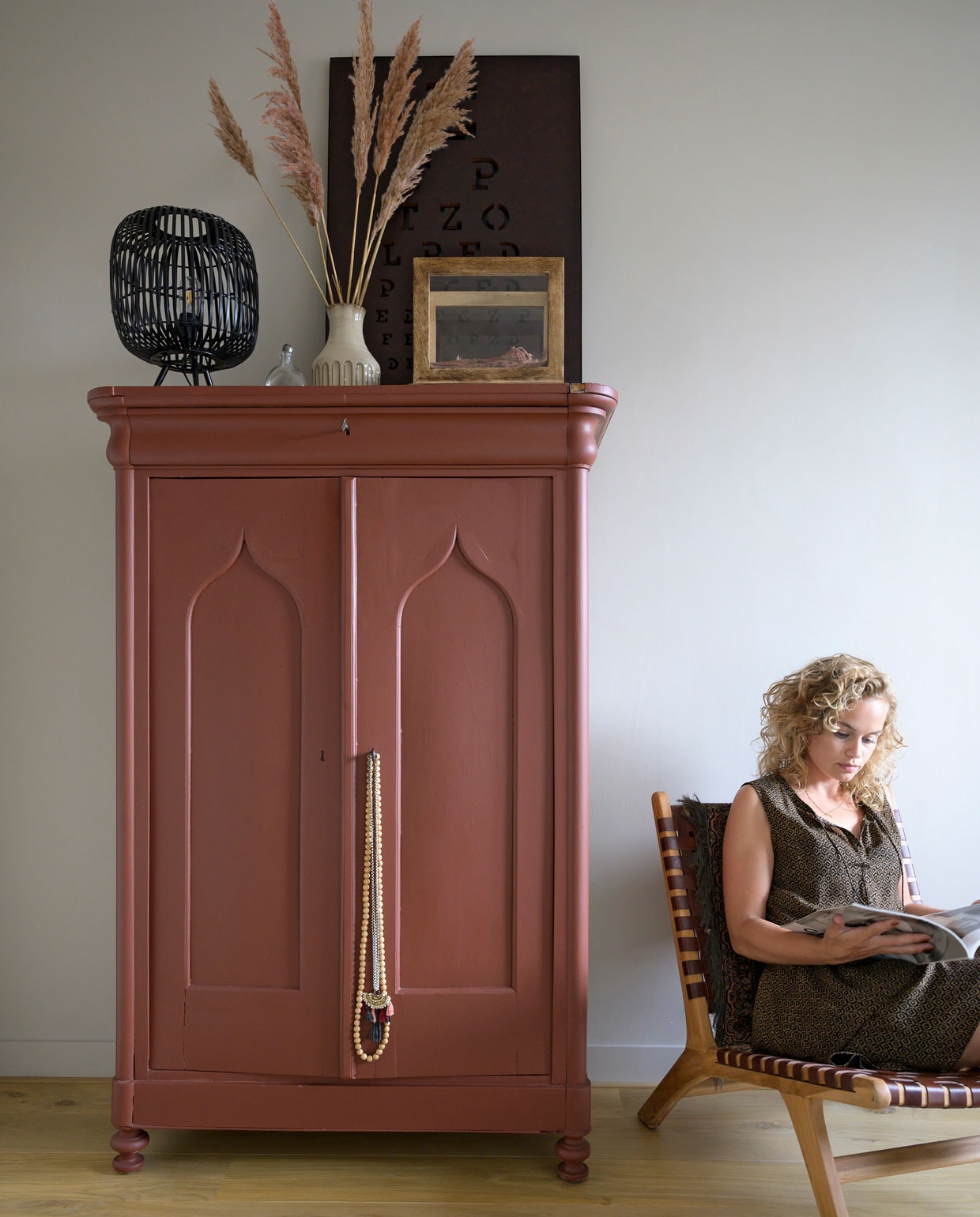 Vintage linnenkast, geverfd in steenrood PPG16-08 van Sigma. Lamp Deens. Wit vaasje cadeau gekregen. Letterbak en kubusvitrine Casa Vivante. Fauteuil Mica Decorations. vtwonen 08-2021 | styling José Spaans | fotografie Stephanie Driessen