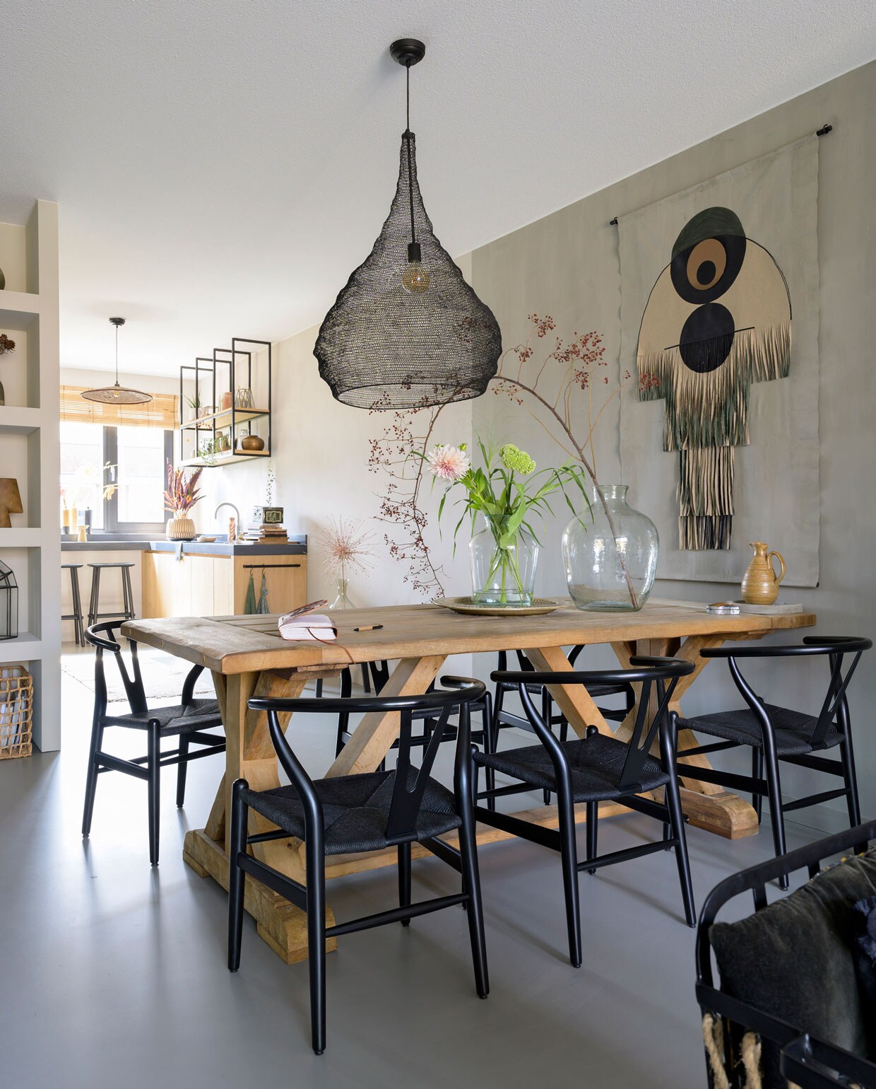 Tafel op maat laten maken door een meubelmaker. Lamp en vazen Mica Decorations. Stoelen Dames van Rusticus Styling. Wandkleed zelfgemaakt. Vloer Fusion Gietvloeren. Kan en servies cadeau gekregen. vtwonen 08-2021 | styling José Spaans | fotografie Stephanie Driessen