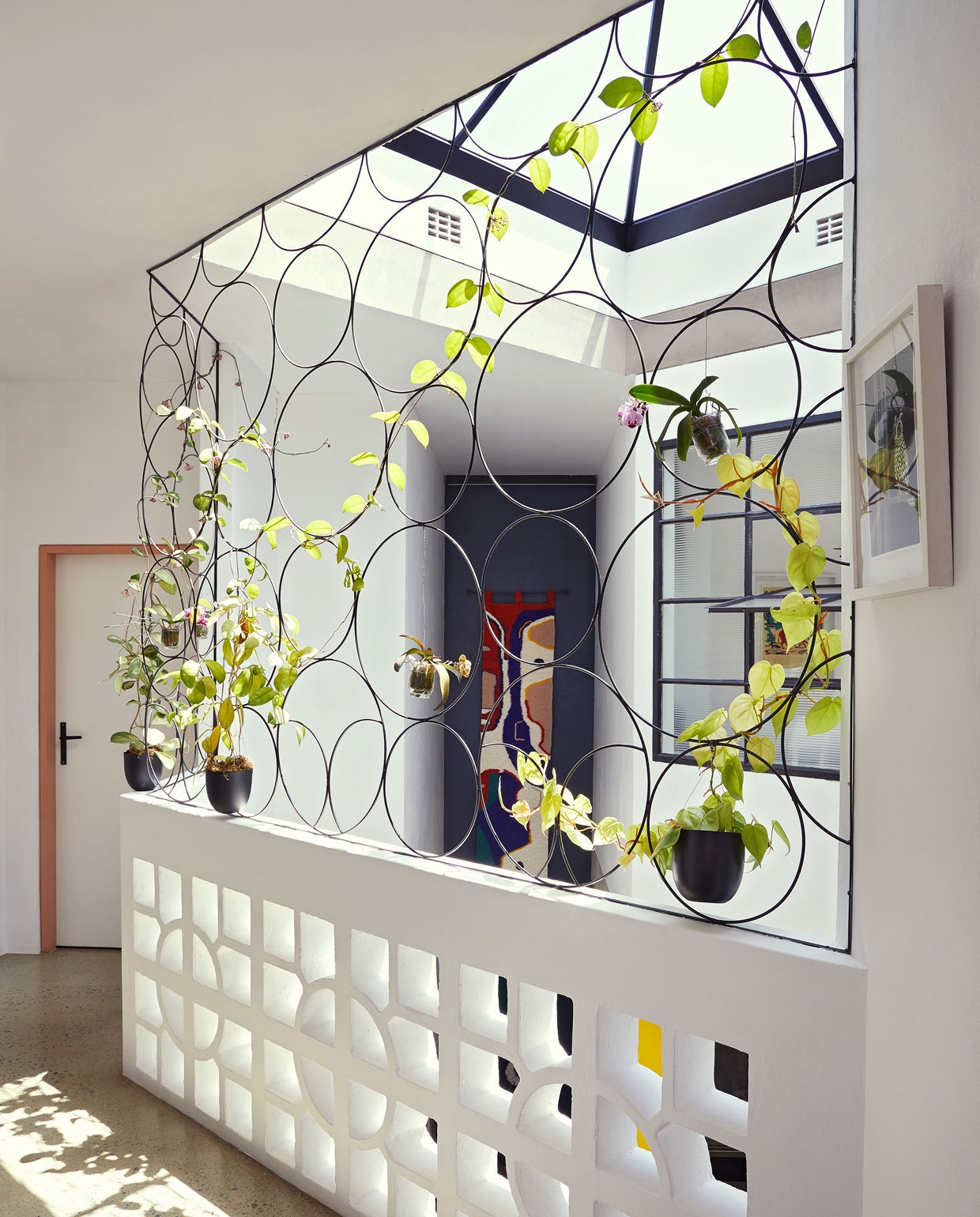 Balustrade eigen ontwerp, gebouwd door Njabulo Steel. Planten Sawasdee Orchid and Bonsai Emporium. Wandkleed Renée Rossouw. vtwonen special binnenkijken 06-2021 | productie Living Inside, Bureaux | fotografie Elsa Young