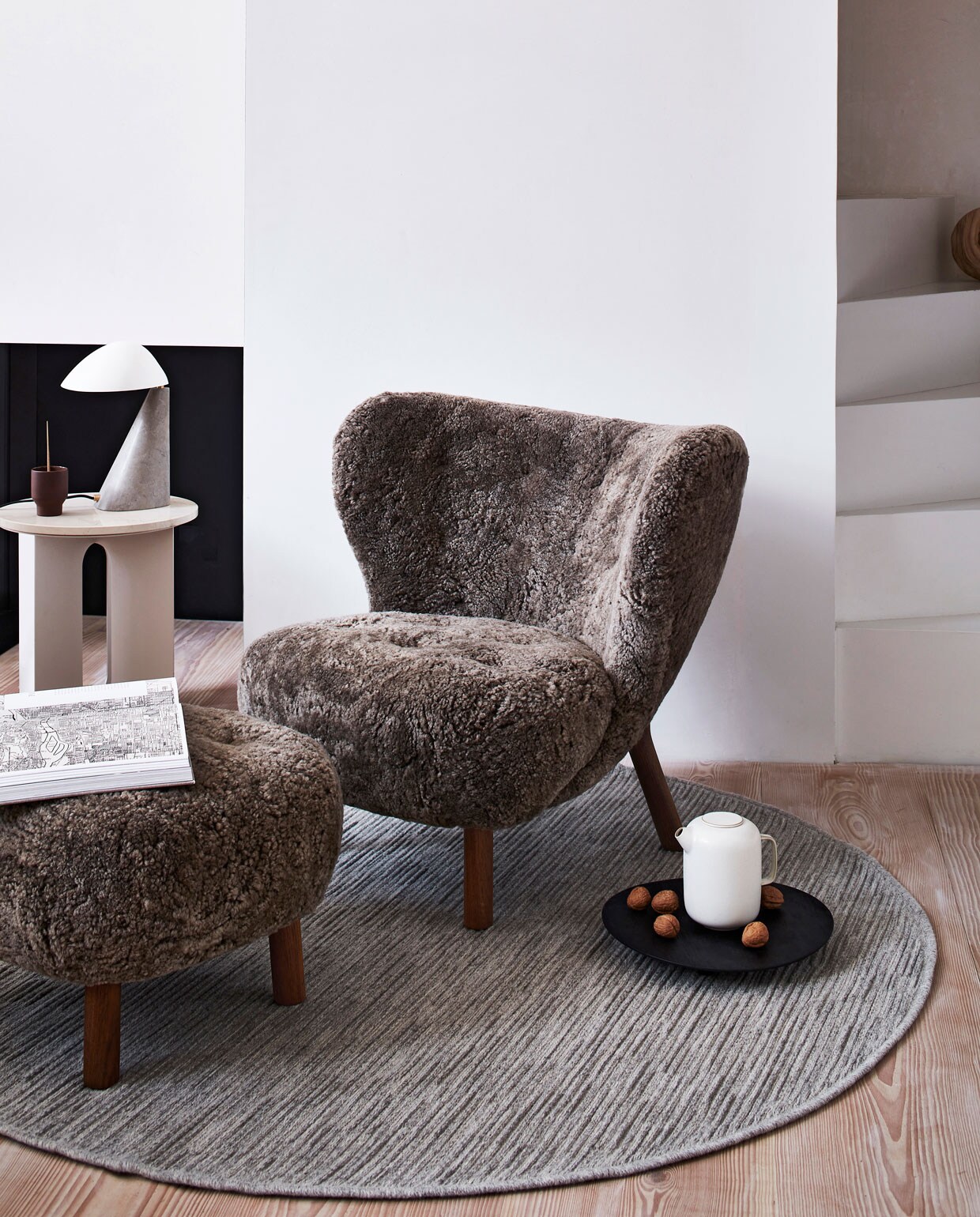 Wollen karpet Nature cord antraciet melé, 160 cm (Ø) Ook verkrijgbaar in 200 cm (Ø) ). M.m.v. vantil.nl (fauteuil, voetenbank), designtales.nl (marmeren bijzettafel, tafellamp), letoile.store (bruine mok), sissy-boy.com (zwart dienblad). Overig privébezit. Productie Tanja Saarberg | styling Danielle Verheul | fotografie Sigurd Kranendonk | assistentie sanne ketelaar