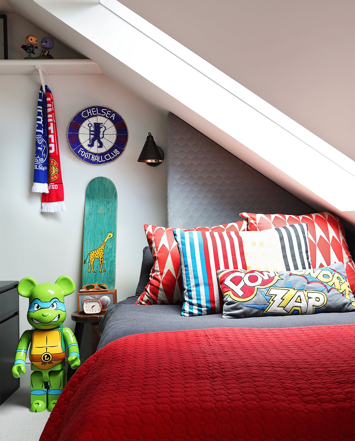 Lamp Game Wall House Doctor. Skateboard Palace. Naast het bed staat een groene Bearbrick: Leonardo van de Ninja Turtles. Kussens zelfgemaakt en van de markt. Beddengoed Zara Home. Plaid H&amp;M Home. vtwonen special zomerhuizen 07-2021 | productie Sven Alberding/Bureaux | fotografie Elsa Young/Bureaux