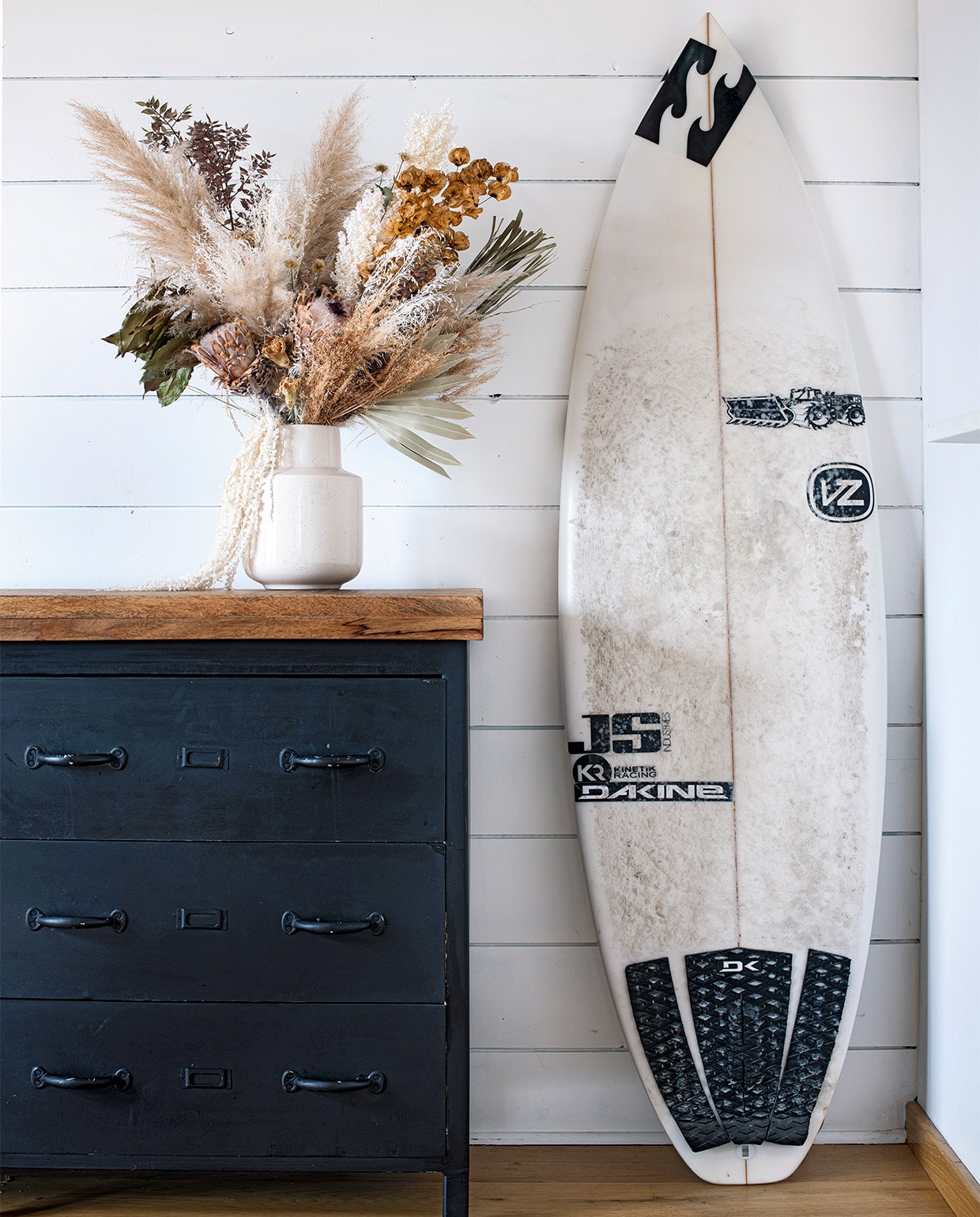 Houten blad op ladekast brocante van Biscarosse. Keramieken vaas Philippine Boho Factory, boeket droogbloemen Teepee Sauvage. De surfplank was van de Australiër Joel Parkinson, wereldkampioen surfen in 2012. vtwonen special binnenkijken 06-2021 | productie Anne-Catherine Scoffoni | styling Catherine Cornille | fotografie Patrick Sordoillet