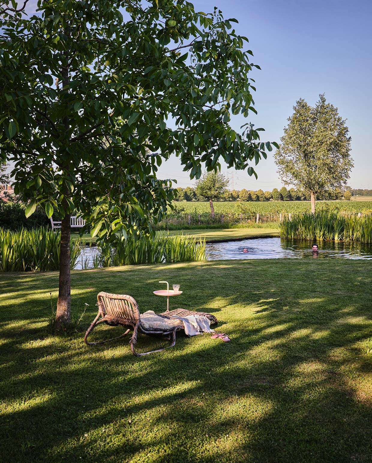 Daybed Piet-Hein Eek voor Ikea, erop een schapenvacht van Texels schaap. Zachtroze bijzettafeltje Hay. Hammamdoek Sissy-Boy Homeland. vtwonen tuin special 3 2021 | styling Carolien Schrievers | fotografie\nRené van der Hulst |