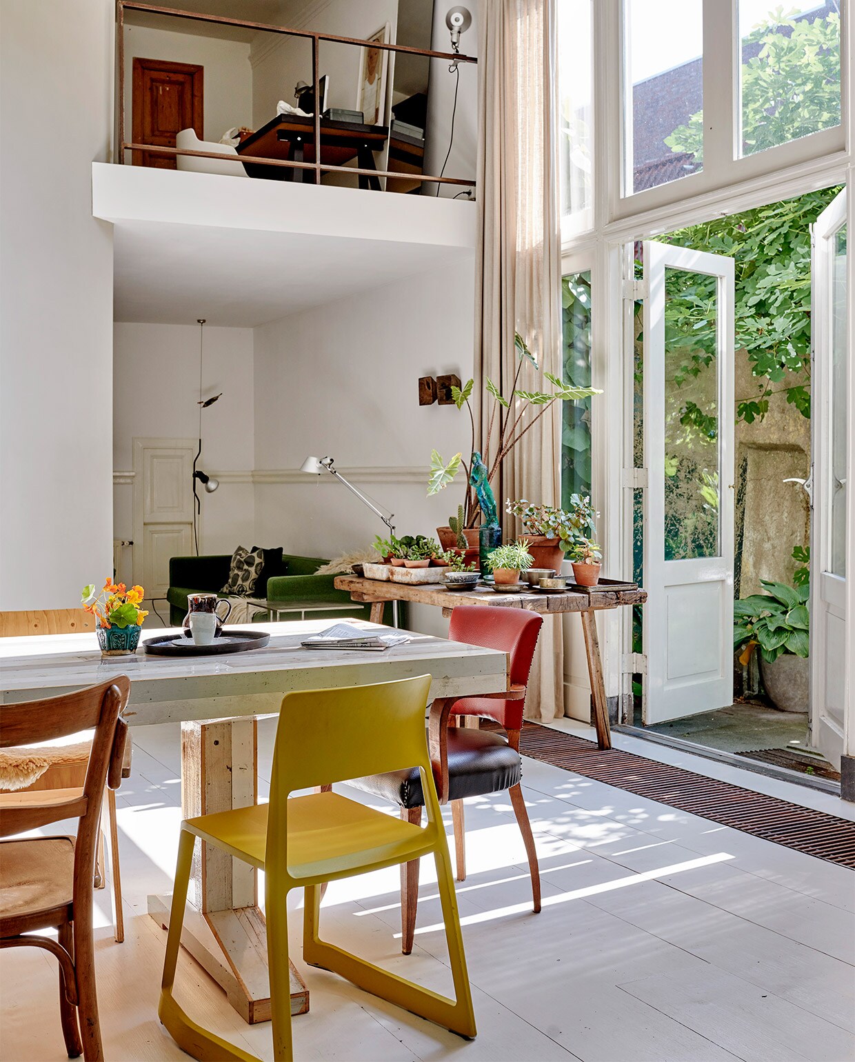 Oude grenenhouten vloer, wit geschilderd. Gele stoel Tip Ton van Vitra via Van Duivenboden. Eettafel Kantinetafel en stoel rechts voor Piet Hein Eek. Kandelaar Twiggy Large Sjakie’s. Kast Chiffonnière. Vogel raaf en dienblad Pols Potten. Kunst transfer op rijstpapier in houten lijst van Laurien Mulder. Papiermaché rat van Caroline de Bruijn. Vaas op tafel MrsBloom. Overig herkomst onbekend. vtwonen 07-2021 | productie Features &amp; More | styling Wilma Clusters | fotografie Renee Frinking | tekst Chantal Hintze | tekstbewerking Laura Zuidema
