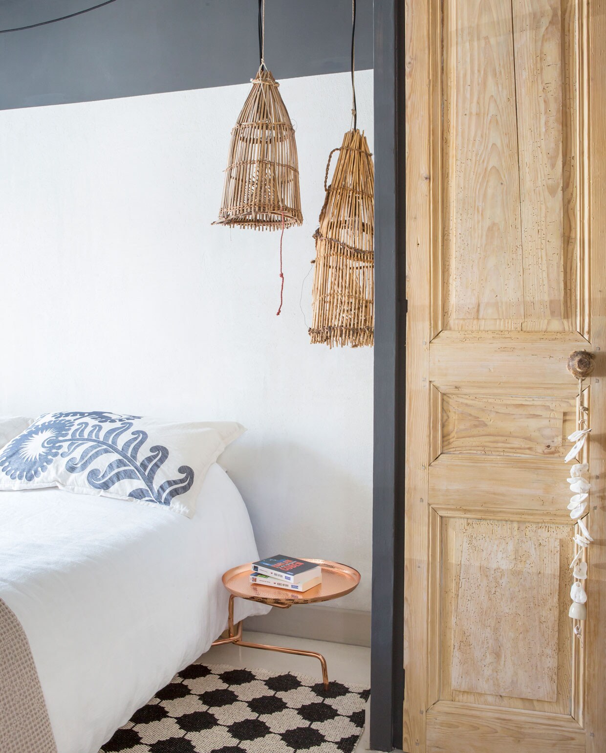 Beddengoed AM.PM via La Redoute, plaid en kussenslopen Habitat. Hanglampen gemaakt van oude visnetten. Koperen bijzettafel Phobos van Marie Christine Dorner voor Ligne Roset. vtwonen binnenkijken special 07-2021 | productie Anne-Catherine Scoffoni |fotografie Pauline Legoff