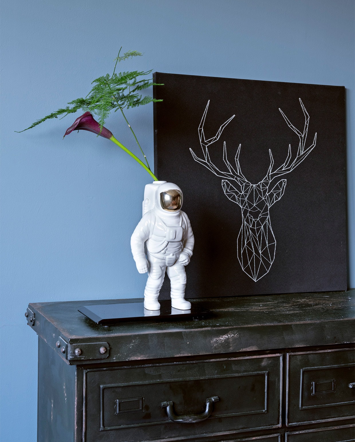 Muurverf Denim Drift van Flexa. Ladekast Loods 5. Vaas Astronaut van Diesel by Moroso. Zwarte onderzetter vintage. Herkomst hertenprint onbekend. vtwonen 07-2021 | styling Sharon Roest | fotografie Caroline Martinot