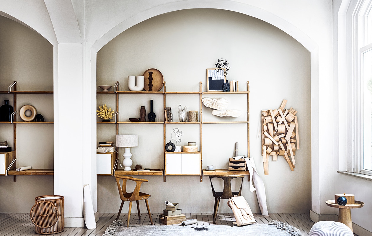 Muurverf Old Flax van Pure & Original (deruamsterdam.nl). Wandmeubel Svalnäs, rek, plank, werkblad met 2 lades, kast met deuren 61x35x39 cm (bxdxh), ronde houten trommel(ikea.nl). Vloerkleed, schilderij, leren tas Puc, mok, bord, pasjeshouder, notitieboek, kleine bezem, posters op de grond (sukha.nl). Mand, grote bruine glazen flesvaas, zwarte olifant, kunstkoraal met zwarte voet, donkerbruine kandelaar op bovenste plank, vergrootglas, houten bak links op kast, leren bakje midden in kast (zarahome.com). Ronde vaas, schaal op voet, houten bakje op bijzettafel (hkliving.nl).Papierrollen prijs op aanvraag, wit doosje met reliëf (badenbaden.nl). Stoel met leren zitting, stoel met donkere houten zitting, rond dienblad van Fritz Hansen (kasstoor.nl). Houten bak met leren lussen, houten ladenbak, (pantoufle-design.nl). Klos touw prijs op aanvraag, glazen vaas met twee openingen op middelste plank, houten kunstwerk op de wand (bolia.com). Takken (waterdrinker.nl). Zwarte marmeren bol, beige boekje met zwarte tekst (hm.com). Kunstobject Wired Lady op witte voet (neeltjegeurtsen.com). Witte vaas met twee openingen Kink van Muuto, poef Bonnet van Casalis, small, donkere houten kandelaar op middelste plank (homestede.nl). Ronde beige voorraadpot met deksel Terres de Rêves van Serax, zwart vaasje With Love from Nature van Serax, 20 cm (h), bijzettafel Luna van Bloomingville, 44×54,5 cm (Øxh), ronde zwarte vaas van Bloomingville 19,5 cm (h), bakjes van Ferm Living op de grond (vtwonen.nl). Takken (waterdrinker.nl). Lamp met lampenkap Fero van Heathfield & Co, zwarte vaas met lange hals Long Neck van Kumanec (loggerewilpower.com). Kunstobject zwamvorm van moerbeipapier (elsavisser.com). Overig privébezit. vtwonen 08-2021 | styling Liza Wassenaar | fotografie Sjoerd Eickmans