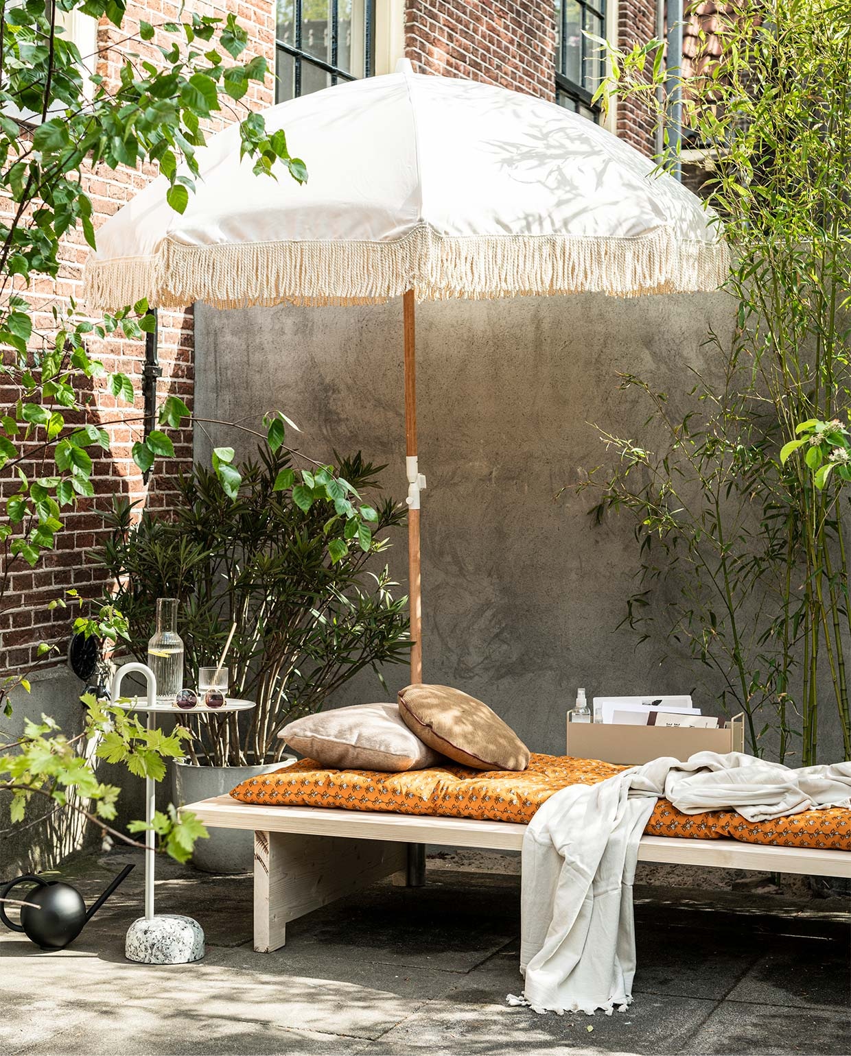 Parasol Dunes (sundaysupply.co). Matraskussen (zarahome.com). Zonnebril, gevlochten slippers (stories.com). Badlaken, glazen (hm.com). Bijzettafel Bowler van Hay, metalen box van Ferm Living in kleur Cashmere, geribbeld glas van Ferm Living (vtwonen.nl). vtwonen 06-2020 | styling Kim van Rossenberg | fotografie Sjoerd Eickmans