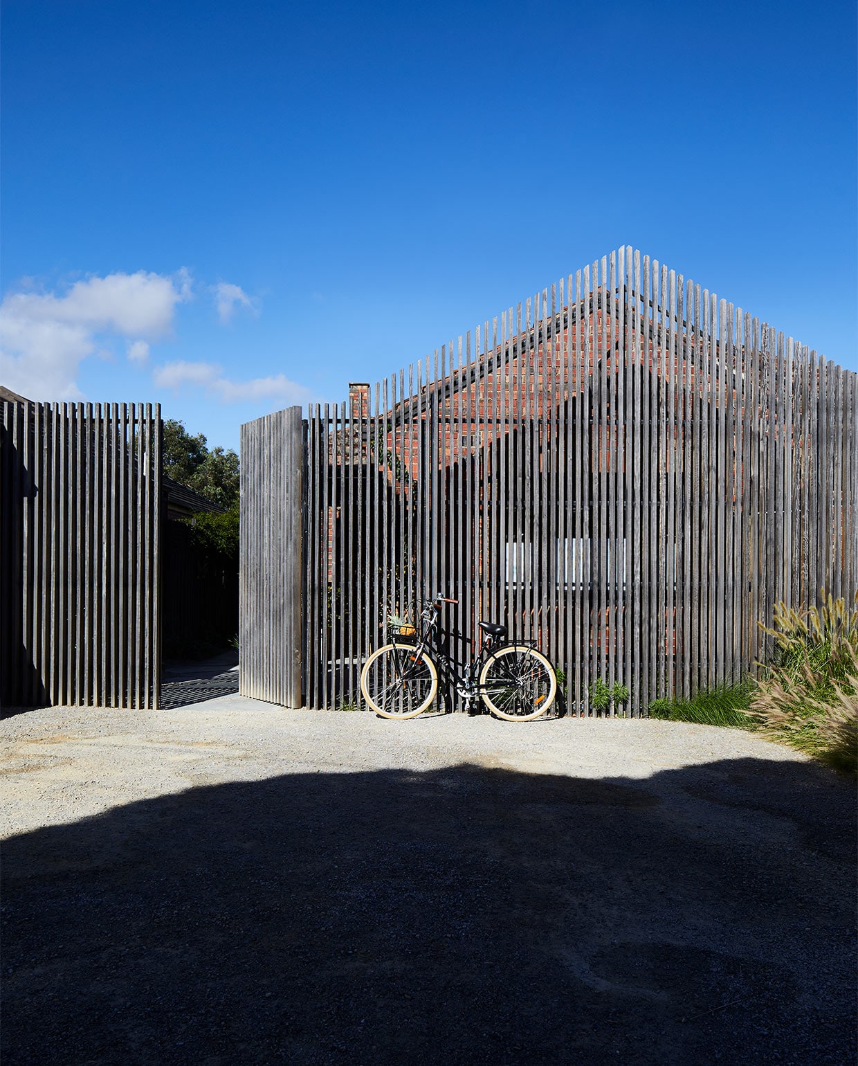 Het buitenhek, een ontwerp van Field Design Studio, volgt de contouren van het huis. Het is gemaakt van in de oven gedroogd hardhout, dat met de tijd mooier wordt. vtwonen binnenkijk special zomerhuizen 07-2021 | productie &amp; styling Living Inside | fotografie Armelle Habib