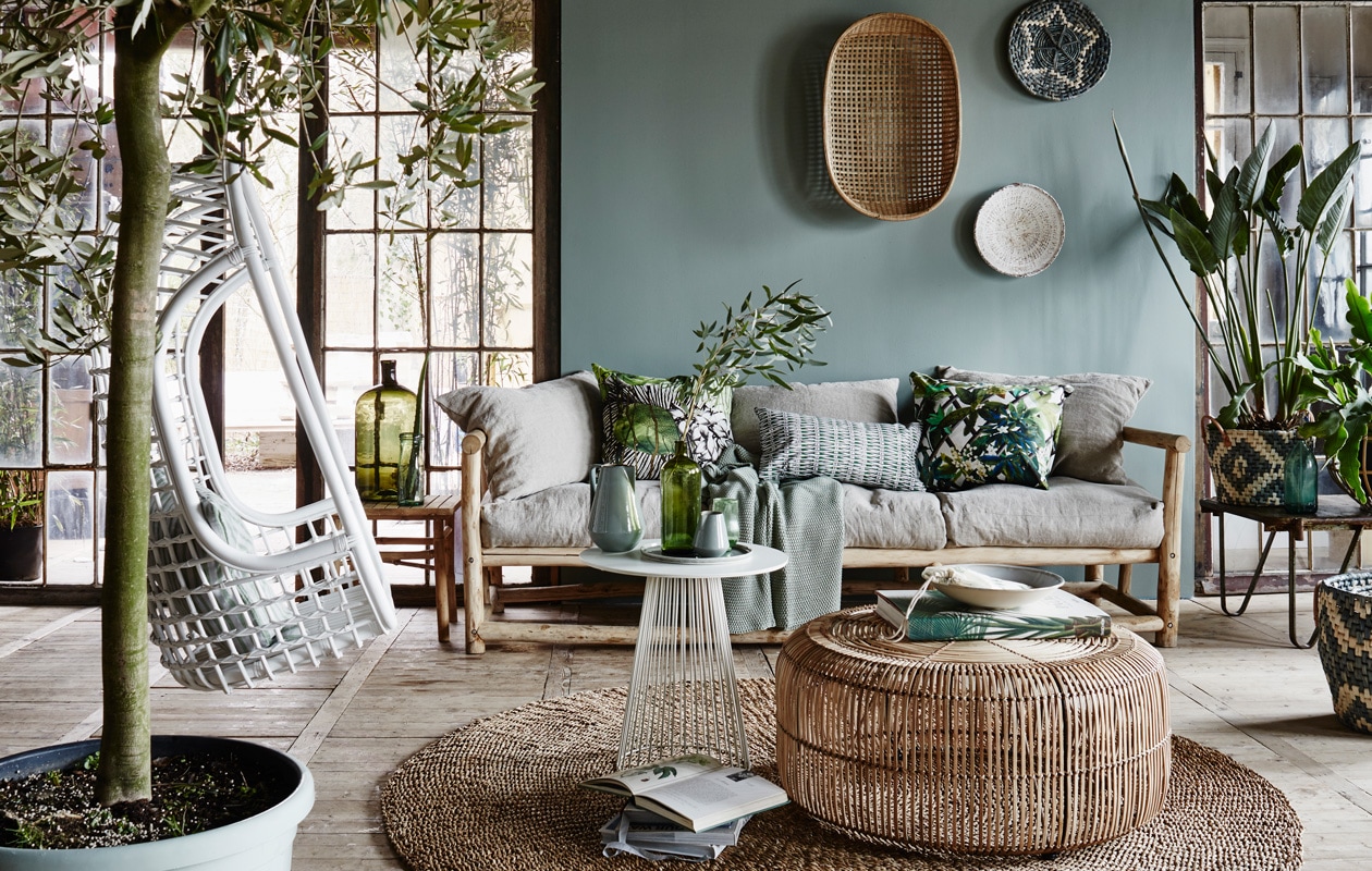 Driezitsbank inclusief zeven rug -en zitkussen Sukha. Zachtgroene plaid in grof weefsel Dille &amp; Kamille. Decoratiekussens van Christian Lacroix, Jardin Exo’chic Rainette, Barbade Malachite en Canopy Malachite Wilhelmine van Aerssen. Bamboe bijzettafel van Tine K Home, l’ Etoile Conceptstore. Tafel Krosno Brut Amsterdam. Rieten mand Graphic van Bloomingville, set van drie, Sukha. Ovale mand aan de muur van Tine K Home, l’ Etoile Conceptstore. Hangstoel van HK Living, vtwonen.nl/shop. Vloerkleed van Bloomingville, l’ Etoile Conceptstore. vtwonen 04-2015 | fotografie Alexander van Berge | styling Cleo Scheulderman