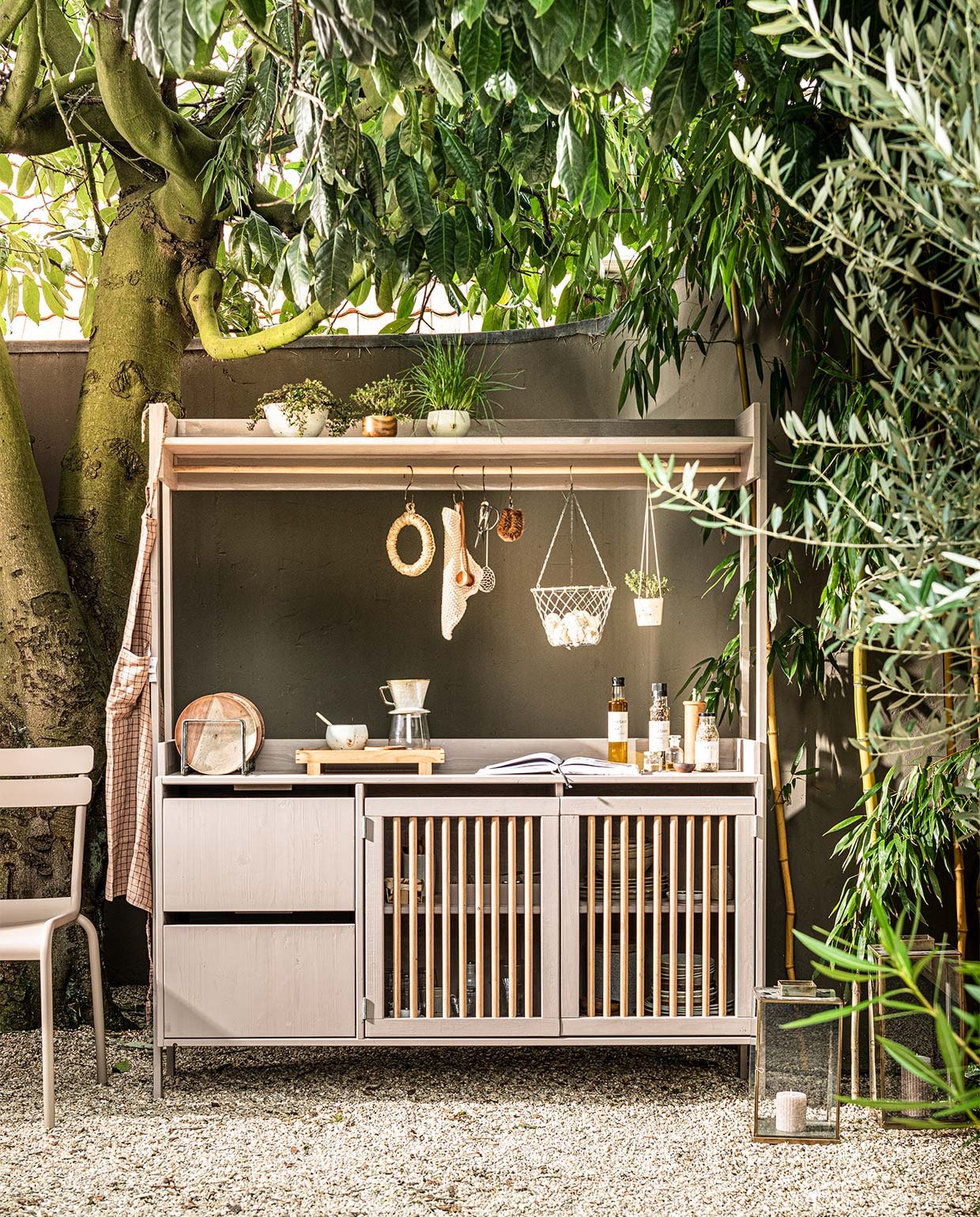 Aluminium outdoor lounge sofa Olive, kussens outdoor lounge sofa set brown (hkliving.nl). Antieke lantaarn ML (nordal.eu). Brass S-hook, bruin geruit schort, acaciahouten borden, metalen bordenhouder, hanging basket, keramieken koffietrechter, glazen kan, beige gebreide pannenlap Mynte, fles olijfolie, fles peper, flesje kruidenpastamix, gouden salt spoon, klein acaciahouten schaaltje (iblaursen.nl). Houten dienbladBon van Ferm Living (flinders.nl). Acaciahouten kom van Serax (vtwonen.nl). Chinees fonduenetje, roestvrijstaal, ronde onderzetter zeegras, kleine glazen pot met facetten en gouden deksel, glazen apothekerspot (dille-kamille.nl). Overig privébezit. vtwonen 07-2021 | styling Kim van Rossenberg  | uitvoering Richard van Meerveld  | fotografie Sjoerd Eickmans