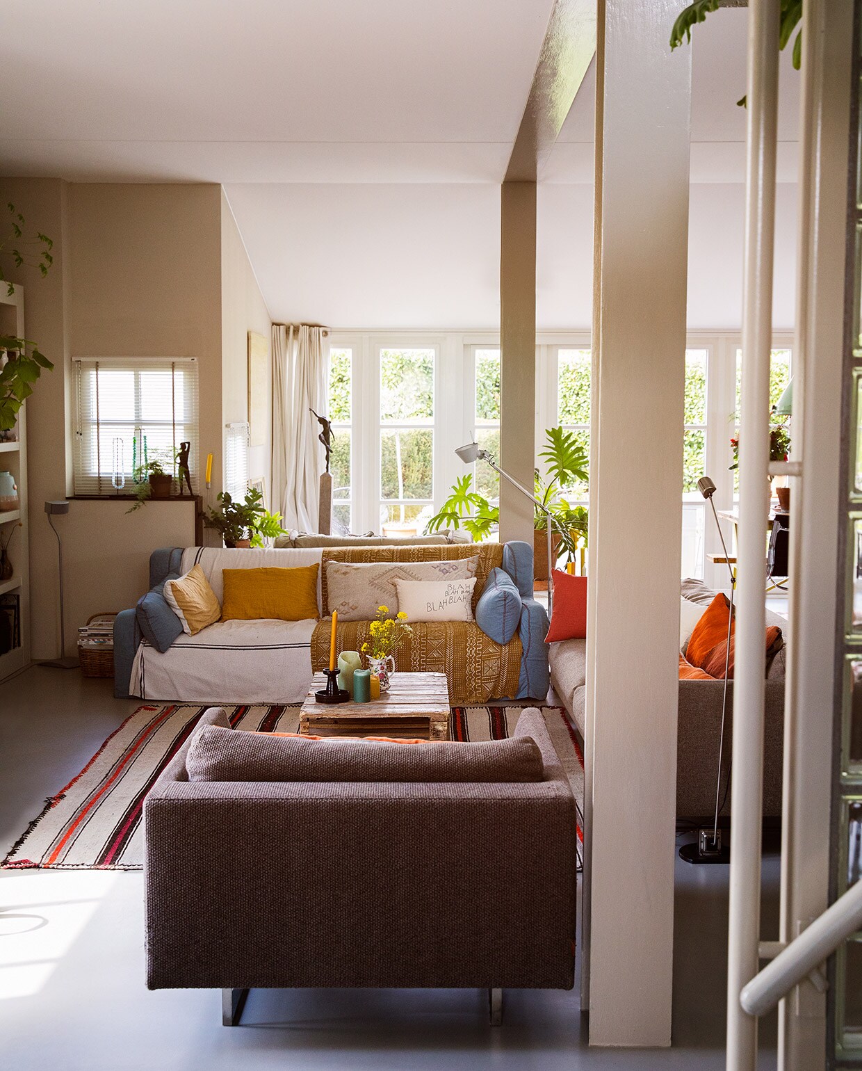 Blauwe bank van Linteloo. Andere bank en fauteuil van Montis. Kleed gekocht in Turkije. Leeslamp links Artemide, rechts Flos. Linnen kussens en blahblah-kussen Lemonwise. Plaid uit Oeganda. Bronzen beeld van Wessel Bezemer. Salontafel gemaakt van een pallet. Kandelaar kringloop. Witte kandelaar in raamkozijn K’willeminhuis. vtwonen 07-2021 | styling Ilona Jongepier | fotografie Dana van Leeuwen