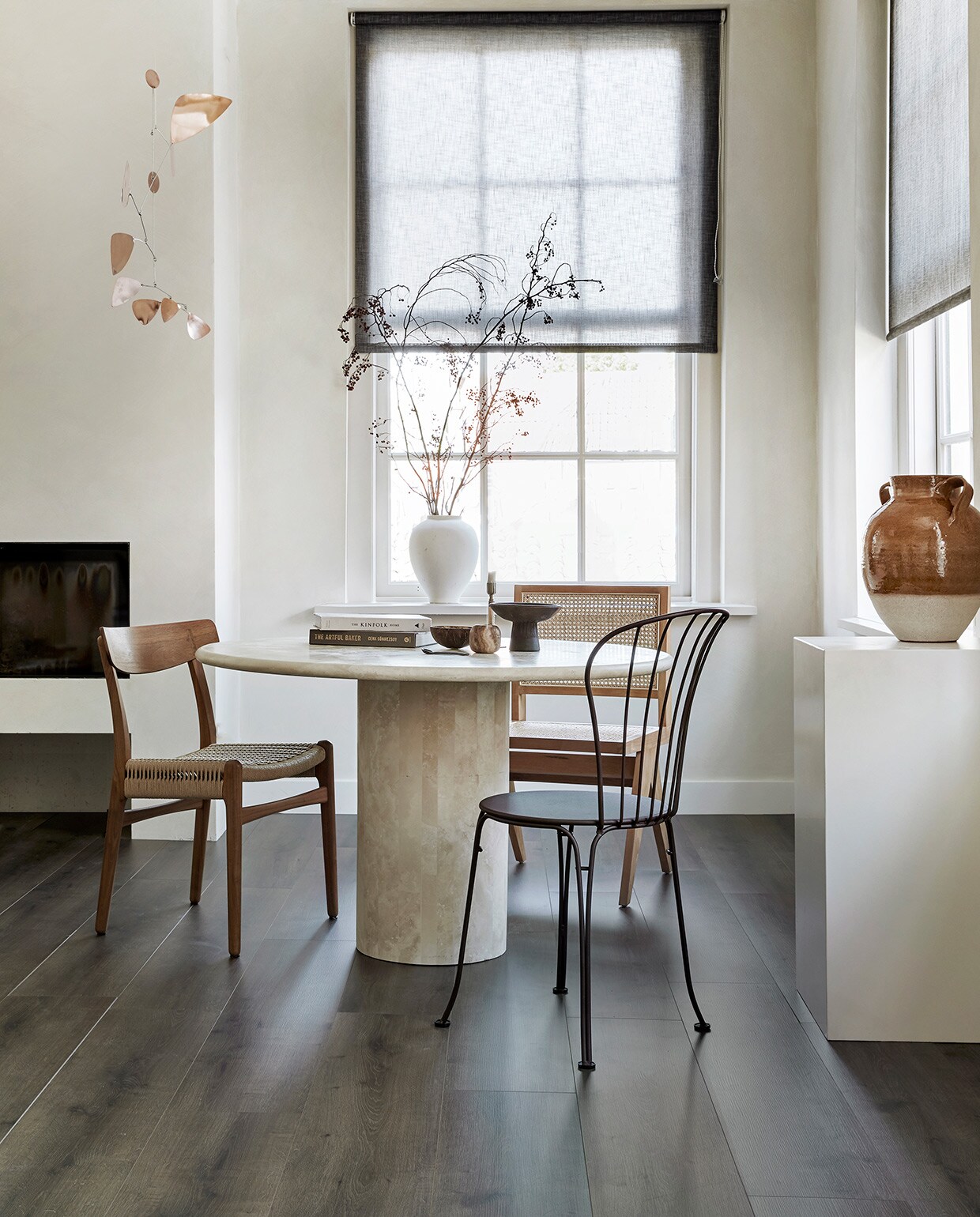EVC vloer Rye per m² € 39,99. , M.m.v. karwei.nl (op maat gemaakt lichtdoorlatend rolgordijn in kleur 37850-700), pantoufle-design.nl (travertin tafel), misterdesign.nl (walnoothouten stoel CH23 van Carl Hansen), casagitane.com (schaal op poot), extravert.nl (bruine stalen stoel Opera van Fermob), aimetestudio.com (houten stoel met rotan zonder armleuning Pierre), zarahome.com (vazen), zenza.nl (alabaster waxinelichthouder), thefinestore.com (kandelaar van Menu), lpln.de (mobile van Lappalainen), bauwerkcolour.com (muurverf in kleur Mykonos). Overig privébezit. vtwonen 08-2021 | productie Tanja Saarberg | styling Kim van Rossenberg | fotografie Peggy Janssen