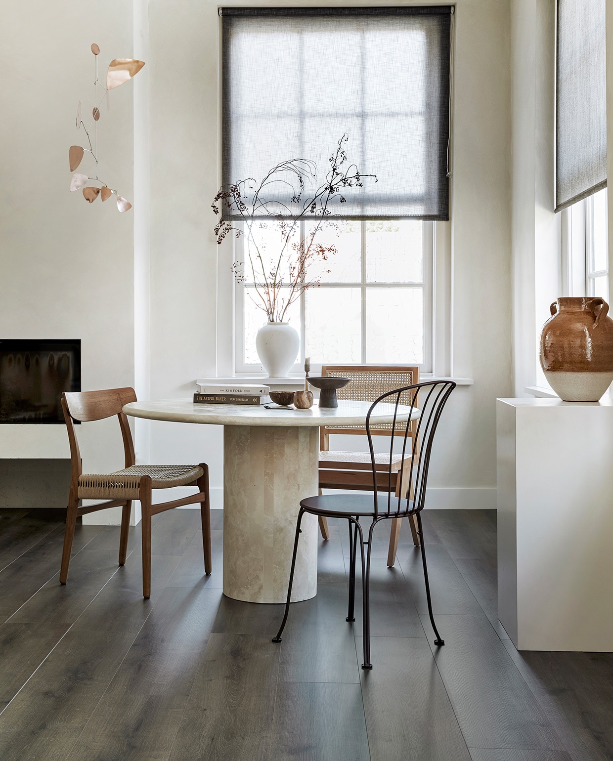 EVC vloer Rye. M.m.v. karwei.nl (op maat gemaakt lichtdoorlatend rolgordijn in kleur 37850-700), pantoufle-design.nl (travertin tafel), misterdesign.nl (walnoothouten stoel CH23 van Carl Hansen), casagitane.com (schaal op poot), extravert.nl (bruine stalen stoel Opera van Fermob), aimetestudio.com (houten stoel met rotan zonder armleuning Pierre), zarahome.com (vazen), zenza.nl (alabaster waxinelichthouder), thefinestore.com (kandelaar van Menu), lpln.de (mobile van Lappalainen), bauwerkcolour.com (muurverf in kleur Mykonos). Overig privébezit. vtwonen 08-2021 | productie Tanja Saarberg | styling Kim van Rossenberg | fotografie Peggy Janssen