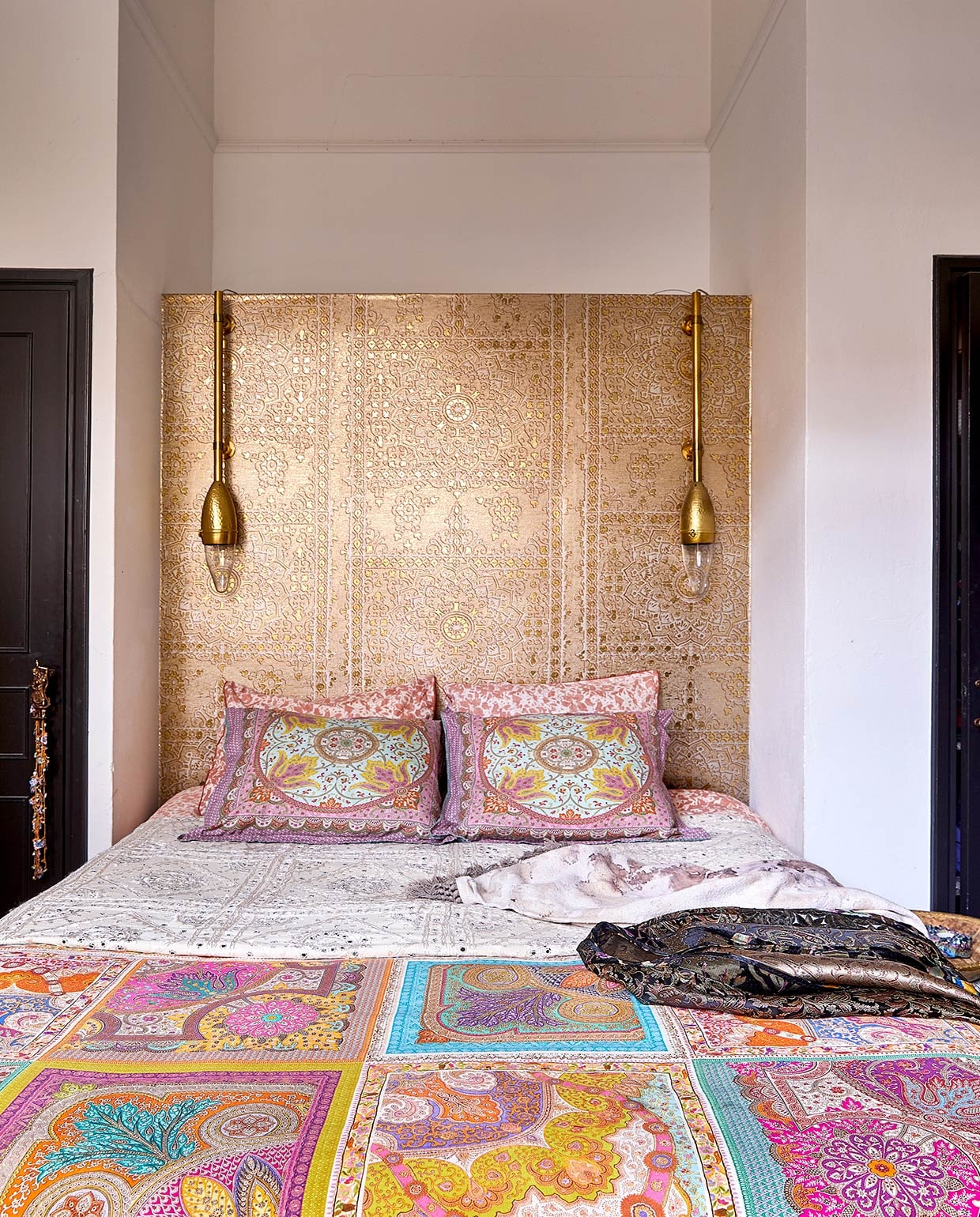 Zelfgemaakt hoofdbord met behang van Luxury By Nature. Lampen Zenza, Karin heeft er buizen aan bevestigd. Kussenhoezen Zara Home. Traditionele witte sprei met spiegeltjes uit India. Kimono zelfgemaakt. vtwonen 06-2021 | productie Coco Features | styling Linda van der Ham | fotografie Peggy Janssen