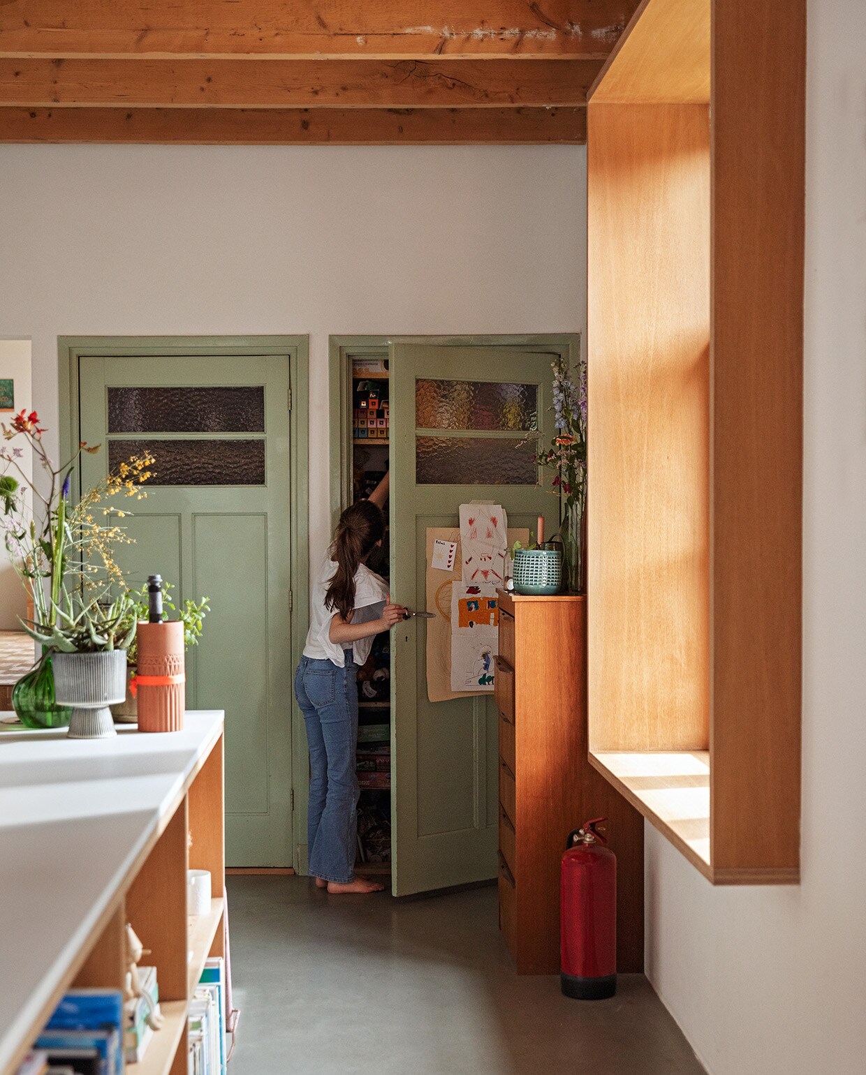Groene vaas rommelmarkt. Grijze vaas Kwantum. Oranje flessenhouder Ikea. Dressoir vintage. vtwonen 03-2021 | Styling Ilona Jongepier | Fotografie Dana van Leeuwen | Tekst Sara Madou