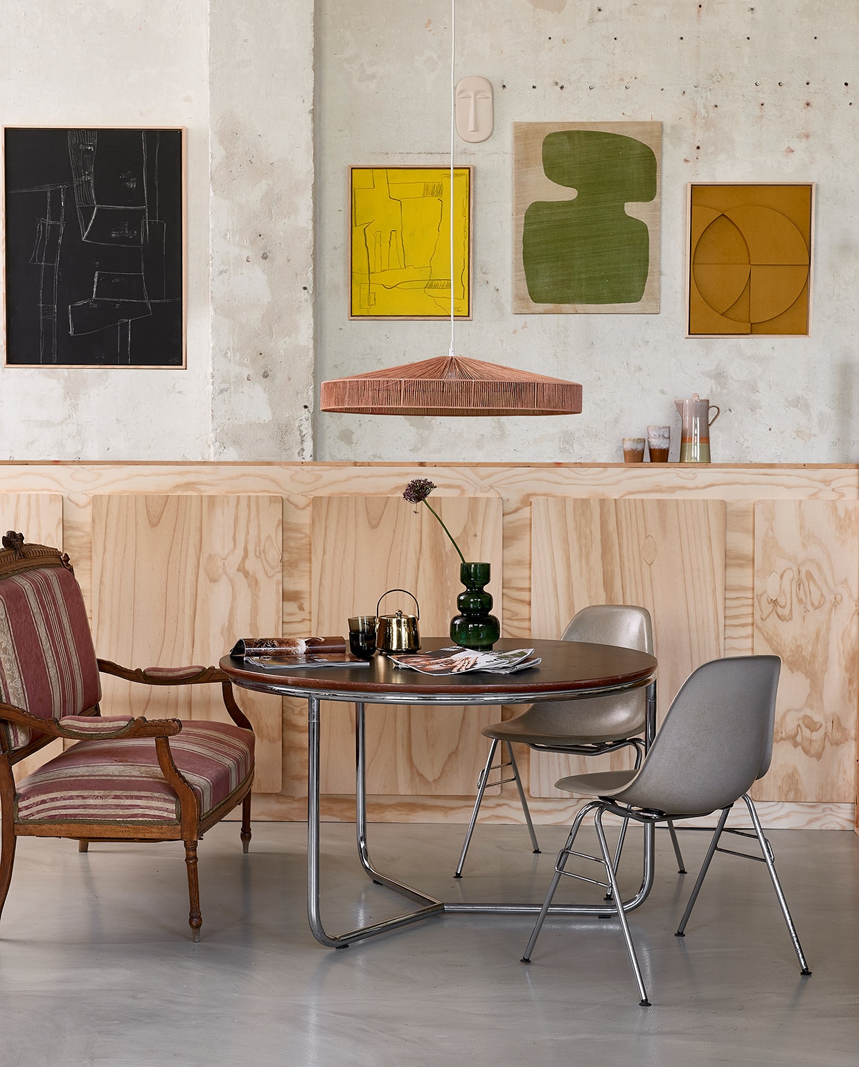 Vintage tafel, 100×76 cm (Øxh), vintage Eames kuipstoel (neeflouis.nl). Antiek bankje (vandijkenko.nl). Kunst aan wand: zwart, 60×80 cm, geel, 40×50 cm en oker, keramieken masker Chulucanas, hanglamp Terra Shades van touw, goudkleurige theepot, koffiekan Saturnus, mokken (hkliving.nl). Wandkleedvan Urban Nature Culture, 65×50 cm, diepgroene glazen vaas, 25 cm (h) (vtwonen.nl). Glaasjes (hm.com). vtwonen 06-2021 | styling Fietje Bruijn | fotografie Dennis Brandsma