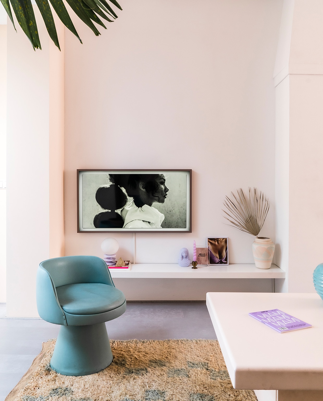 Muur, wandplank en salontafel geschilderd in kleur Ontwaak Histor. Vintage stoel en salontafel Marktplaats. Vloerkleed The Souks. Televisie The Frame van Samsung met een Pinterest-foto erop. Vintage lila bollamp Enter My Attic. Lila geverfde buste en kandelaar kringloop. Roze kaars Hay. Print Hello in French Hôtel Magique via . Ingelijst knipsel uit tijdschrift. Vaas meegenomen uit Palm Springs. Groene bolvaas rommelmarkt. vtwonen special tiny houses 03-2021 | fotografie Muk van Lil | tekst Caroline Westdijk