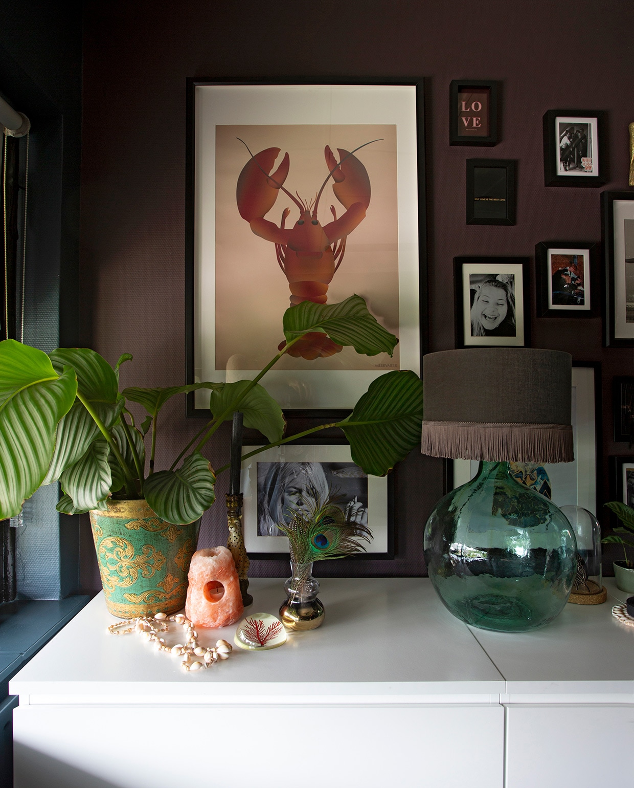 Muurverf Lood Histor. Witte ladekast Ikea. Plantenpot De StadsZolder. Zoutlamp kringloopwinkel. Gouden vaas H&amp;M Home. Fotolijsten Ikea. Print Vissevasse. Tafellamp Scotch Collectables. Print Brigit Bardot Printshop. Schelpenketting rommelmarkt. vtwonen 06-2021 | styling Liesbeth Visschedijk | fotografie Jeltje Janmaat