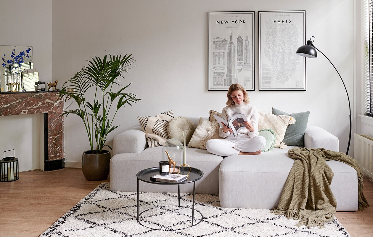 Bank Westwing, zwart-wit kussen en twee groene kussens H&amp;M Home, rond kussen Jysk, drie witte kussens The Weavery Shop, plaid Jysk. Vloerkleed en bijzettafel Karwei. Kandelaar Living-in By Romy’s. Stolp en giraffe Action. Geurkaars Skins Cosmetics. Zwarte vloerlamp herkomst onbekend. Spots plafond lampenlicht.nl. Posters My Guide To New York en Parijs van David Ehrenstråhle, myguideto.se. vtwonen special tiny houses 03-2021 | productie Features &amp; More  | styling Wilma Custers | fotografie Renee Frinking