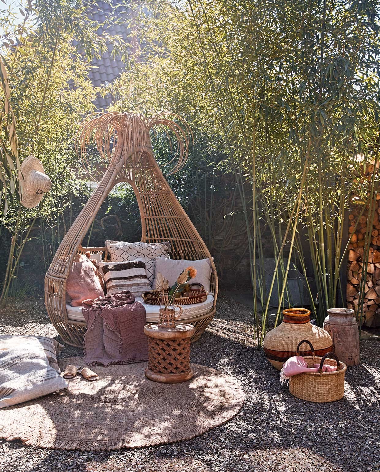 Artie dagbed Bongo, 172x170x218 cm (lxdxh) inclusief matras en kussens (fonteyn.nl). Ronde bijzettafel Bamileke, Ø 40 cm, mand met hengsels, linnen plaid met franjes, platte mand als dienblad, mand in kruikvorm, hoed, klein gestreept berber kussen, 50×50 cm, grote gestreepte kussens, 75×75 cm (couleurlocale.eu). Oranje kussen met kwasten, 65×65 cm, rond jute vloerkleed van Madam Stoltz Ø 180 cm (deens.nl). Karaf met riet (nordal.eu). Naturel linnen kussen, 50×70 cm (vtwonen.nl). Overig privébezit. vtwonen TUIN 02 | styling Cleo Scheulderman | fotografie Jeroen van der Spek