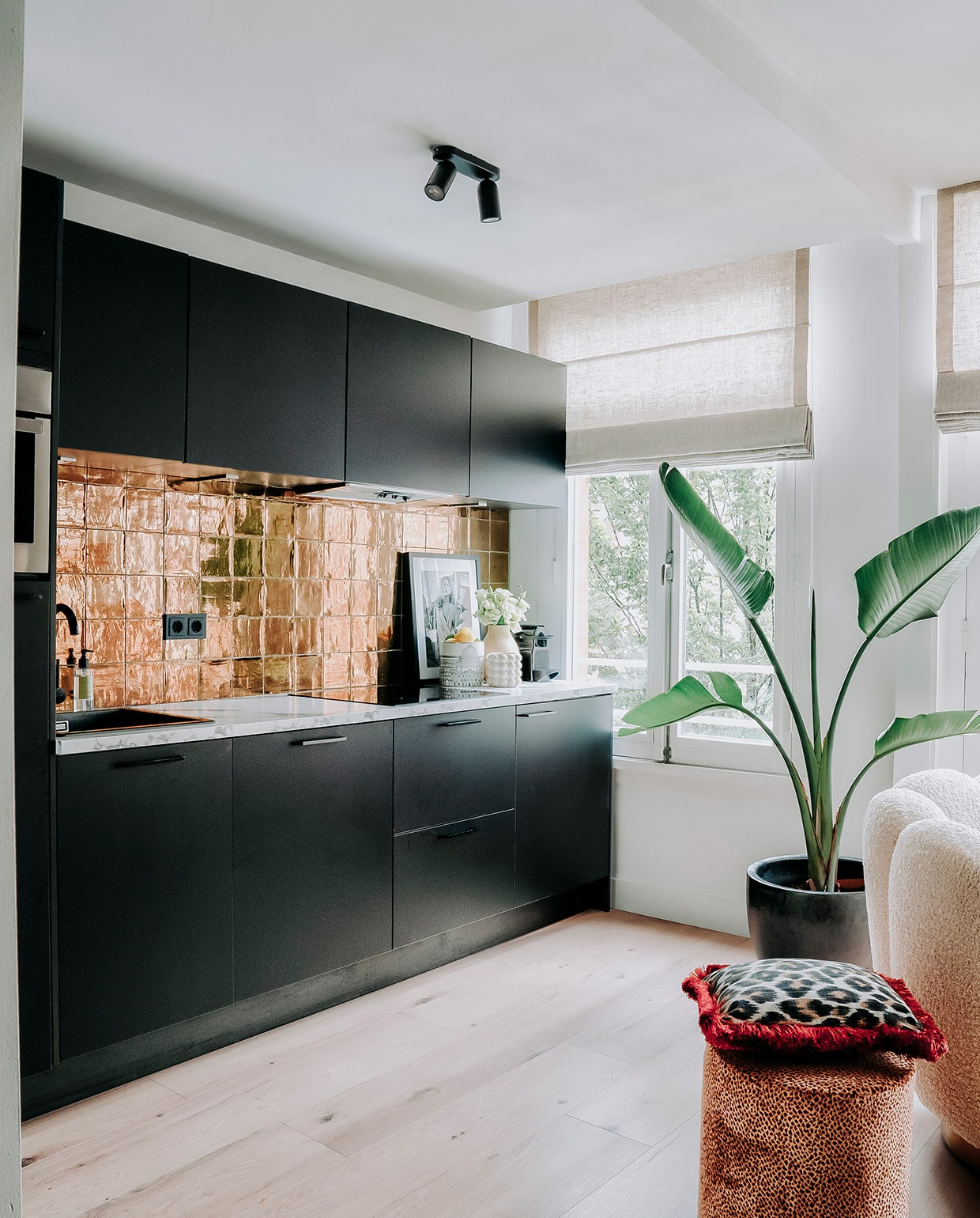Keuken, marmeren werkblad en kraan Kooloos Interieurbouw. Tegels Megadump Tegels en Sanitair, vloer Nijhof. Zeeppompje en vaas Zara Home. Poef, kussen en schilderij Nox Studio Interiors. Plantenpot en plant Intratuin. Witte potten H&amp;M Home. vtwonen 06-2021 | Productie CocoFeatures | Fotografie Muk van Lil | tekst Cathelijne van Wingerden