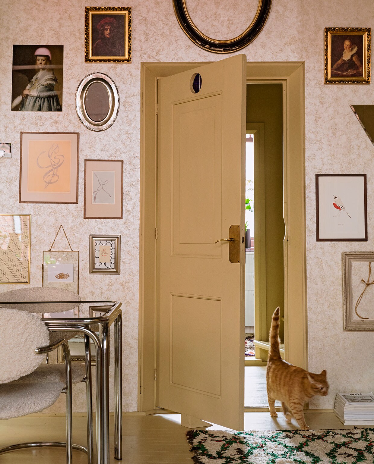 Behang Fenton in goud van 1838 Wallcoverings. Verfkleur houtwerk Bisquit van Painting The Past. Vintage tafel en stoelen Living Once, zelf gestoffeerd. Vloerkleed The Souks. Verzameling lijsten erfstukken, cadeau gekregen en kringloopwinkel. Print Meisje in het blauw met roze helm Arti-shock, print roodborstje Maartje van den Noort, overige herkomst onbekend. vtwonen 06-2021 | styling Ilona Jongepier | fotografie Dana van Leeuwen | tekst Renate Dahlmans