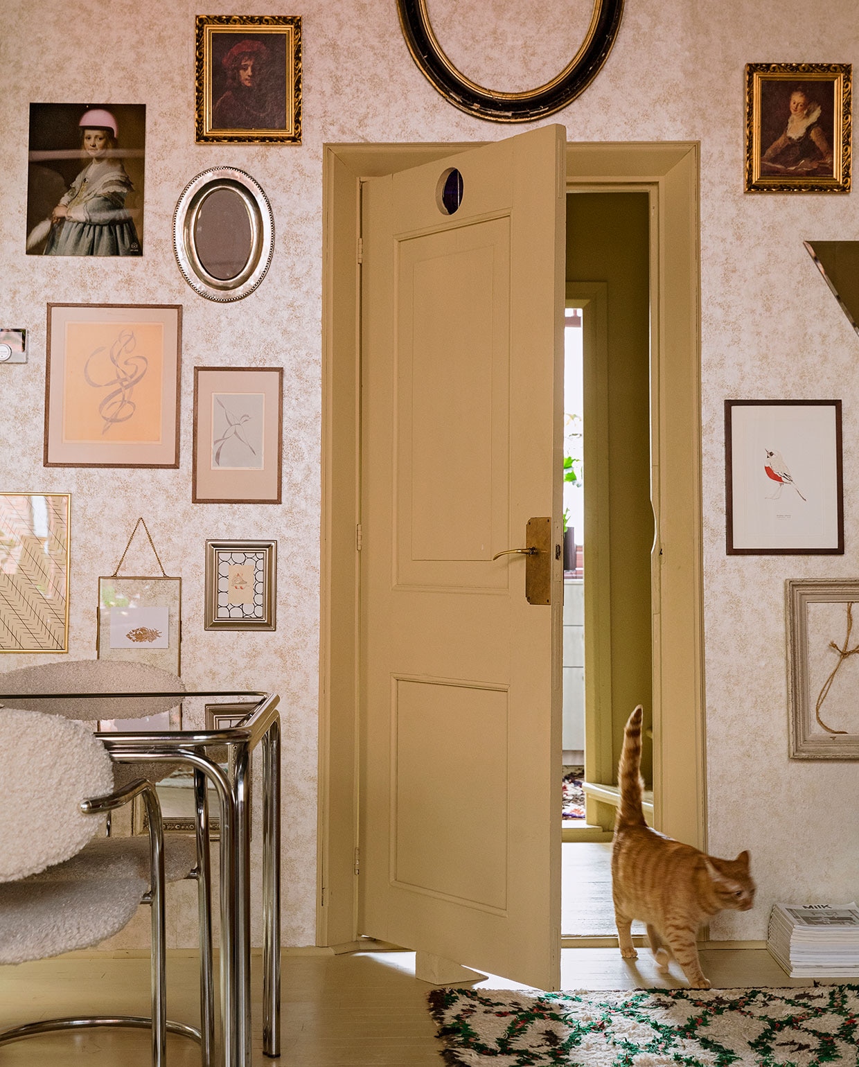 Behang Fenton in goud van 1838 Wallcoverings. Verfkleur houtwerk Bisquit van Painting The Past. Vintage tafel en stoelen Living Once, zelf gestoffeerd. Vloerkleed The Souks. Verzameling lijsten erfstukken, cadeau gekregen en kringloopwinkel. Print Meisje in het blauw met roze helm Arti-shock, print roodborstje Maartje van den Noort, overige herkomst onbekend. vtwonen 06-2021 | styling Ilona Jongepier | fotografie Dana van Leeuwen