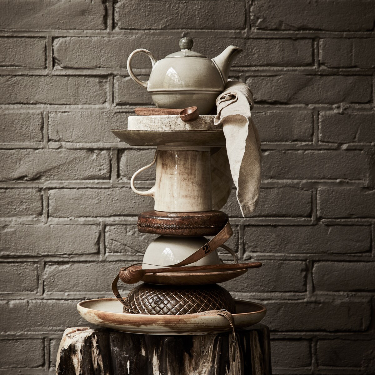 Theepot, stenen siervorm op staander, lunchbord, klassieke theemok uit set met theepot, houten bordje, soepbord met ruitpatroon (loods5.nl). Meetlint (harlequin-lisse.biz). Kleine houten lepel uit set met bakje, linnen theedoek (hm.com). Stenen voet (thewunderkammer.eu). Mok met kleurverloop van Wonki Ware (couleurlocale.eu). Gevlekt bord van HK Living (vtwonen.nl). Grote houten lepel HK Living (mooistoerwonen.nl). vtwonen 13-2019 | Styling Liza Wassenaar | Fotografie Alexander van Berge