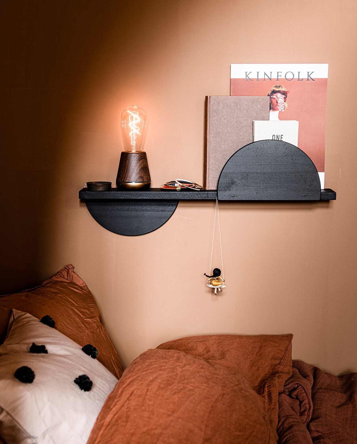 Kussen Dot Tufted van Ferm Living in kleur Sand/Black (vtwonen.nl). Dekbedovertrek en kussensloop in kleur Brick, deken Cinnamon, 100×140 cm van Garbo &amp; Friends (archive-store.nl). Oplaadbare tafellamp Walnut in kleur Satin Brass (humblelights.com). Armbanden (zenza.nl). Memory book One Line a Day (hm.com). Meisje op schommel (dorimu.com). Overig privébezit.