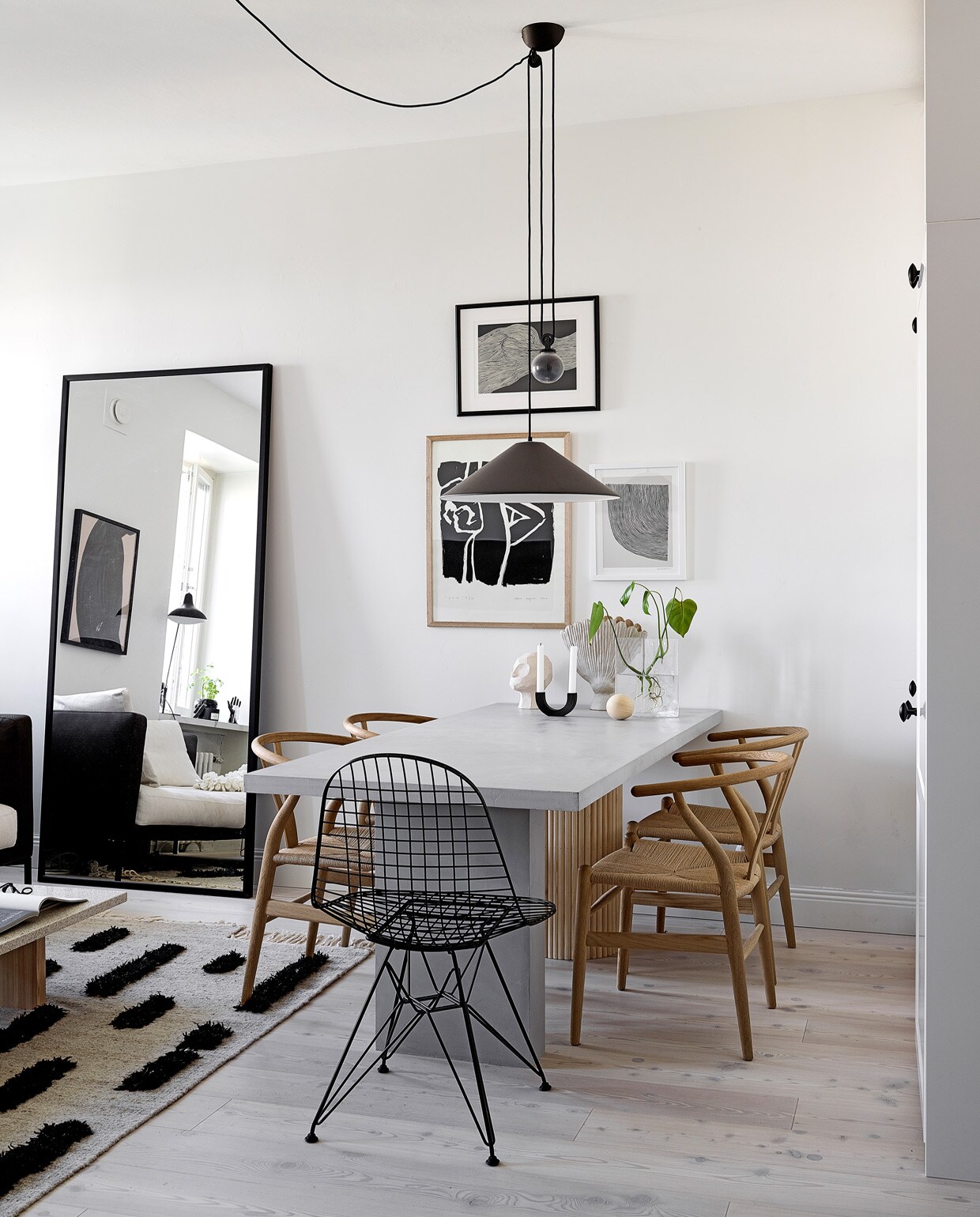 Vloer Timberwise. Spiegel eigen ontwerp, gemaakt door Essis Collection. Vloerkleed Sera Helsinki. Eettafel Bond eigen ontwerp, verkrijgbaar via Decorativi Design. Eetkamerstoelen Wishbone Carl Hansen &amp; Son. Draadstalen stoel Eames DKR Vitra. Keramieken hoofd Kristiina Haataja, ronde kandelaar Ferm Living, keramieken vaas Samuji, glazen vaas Iittala. Hanglamp Aggregato Saliscendi Artemide. Posters The Poster Club. vtwonen special tiny houses | Productie Living Inside | Fotografie Krista Keltanen | Tekst Jonna Kivilahti | Tekstbewerking Adeline Mans