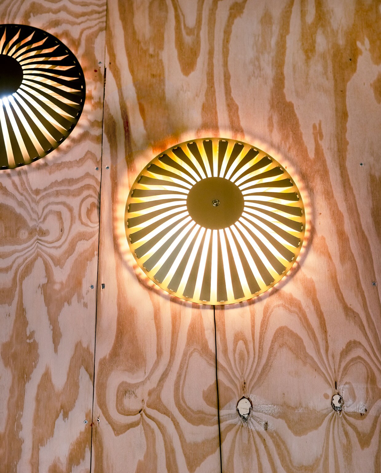 Glint betekent letterlijk ‘kleine, heldere lichtflitsen produceren die door een oppervlak worden weerkaatst’. Lamp Glint, in de collectie van Vij5, doet precies dat; het reflecteert licht op de twee aluminium, in elkaar grijpende elementen, waarbij de armen elkaar overlappen en de lichtbron bedekken. Er ontstaat een poëtisch lichtspel, dat het licht verspreidt op de muren, de vloer en het plafond. Wat de behuizing van geanodiseerd aluminium zo bijzonder maakt; elke kleur heeft zijn eigen effect op de weerkaatsing van de verlichting en geeft het licht zijn eigen intensiteit en kwaliteit. vtwonen 06-2021 | Productie en tekst Bartjan Bouman | Fotografie Ernie Enkelaar