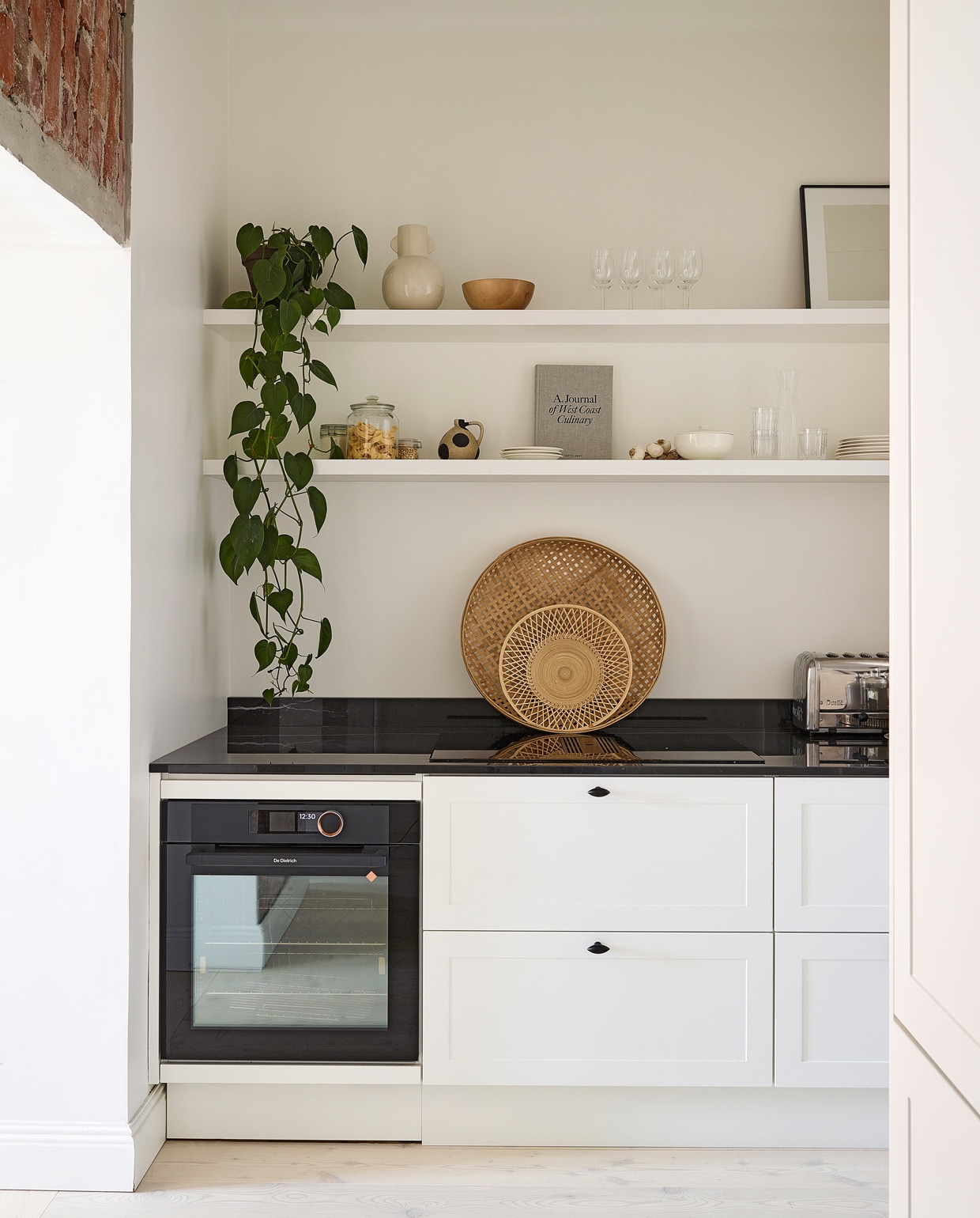 Keuken Nixi. Houten kapstok gemaakt in opdracht. Zwarte cocktailshaker Cosmopolitan Bolia, theebox Teministeriet tea, vaas, wit bord, glazen verstuiver en glazen fles vintage. vtwonen special tiny houses | Productie Living Inside | Fotografie Krista Keltanen | Tekst Jonna Kivilahti | Tekstbewerking Adeline Mans