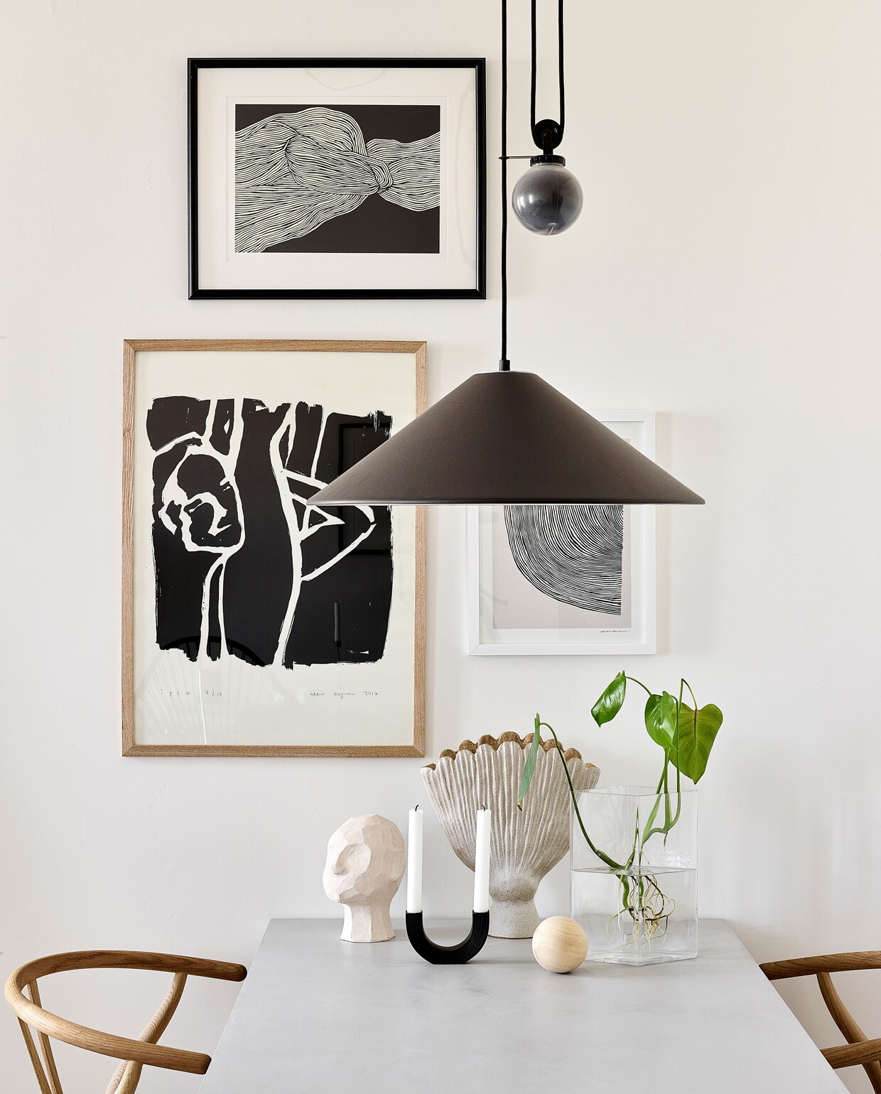 Posters The Poster Club. Eettafel Bond eigen ontwerp, verkrijgbaar via Decorativi Design. Eetkamerstoelen Wishbone Carl Hansen &amp; Son. Keramieken hoofd Kristiina Haataja, ronde kandelaar Ferm Living, keramieken vaas Samuji, glazen vaas Iittala. Hanglamp Aggregato Saliscendi Artemide. vtwonen special tiny houses | Productie Living Inside | Fotografie Krista Keltanen | Tekst Jonna Kivilahti | Tekstbewerking Adeline Mans