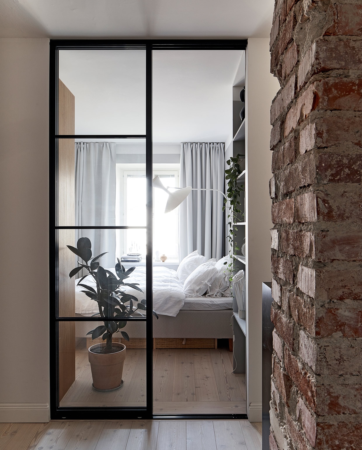 Stalen deur Lasitehdas. Wandlamp Lampe de Marseille Nemo. vtwonen special tiny houses | Productie Living Inside | Fotografie Krista Keltanen | Tekst Jonna Kivilahti | Tekstbewerking Adeline Mans