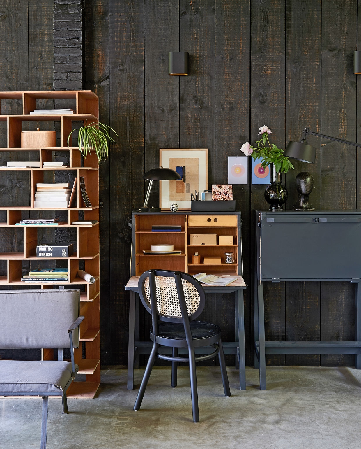 Bureau gemaakt van kisten, fauteuil met stalen frame, vakkenkast (com-anders.nl). Retro stoel, houten opbergbox, wanddecoratie in houten lijst sculptuur No Face (hkliving.nl). Taupe glazen vaas (loods5.nl). Staande lamp (design5.nl). Vintage lampje (demachinekamer.nl). Toolbox van Vitra (vtwonen.nl). Overig privébezit. vtwonen 09-2019