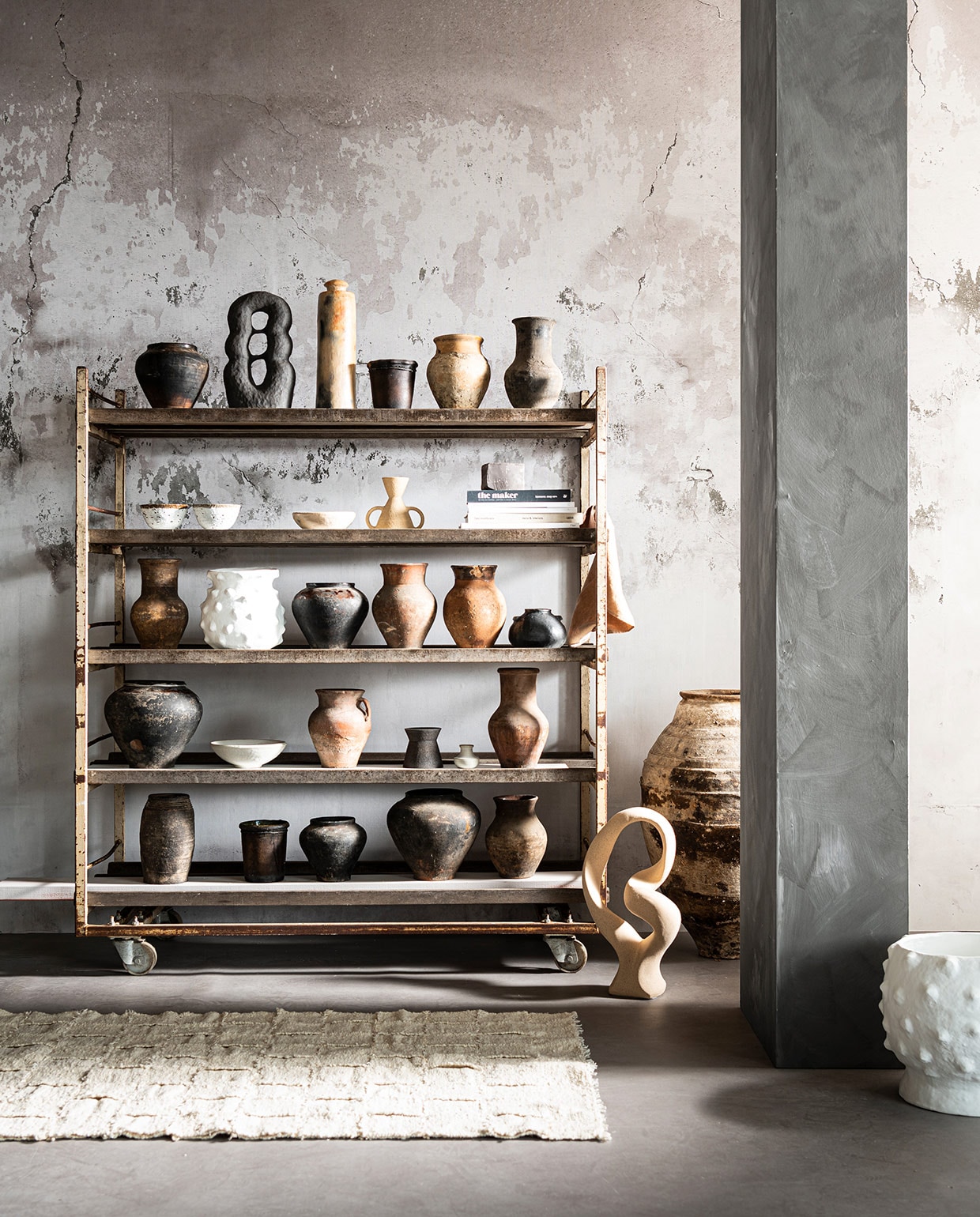 Behang uit Super Grunge collectie, per m² € 80,- (behangfabriek.com). Oud broodrek € 550,- (burbri.nl). Vloerkleed Bat’z Rug € 375,- (studio-yen.com). Grote oude oliekruik € 475,-, witte pot met bubbels Boule Blanc € 189,-, camel-kleurige linnen doek van Linge Particulier € 12, (couleurlocale.eu). Object Stoneware van Bloomingville € 85,- (vtwonen.nl). Bovenste plank: pot van gebakken klei € 35,-, lichte vaas van klei € 35,-, zwarte vaas van klei € 35, (burbri.nl). Object Guaja Sculpture van Malwina Kleparska € 450,- (studio-yen.com). Lange vaas € 126,-, lage zwarte pot € 42,- (couleurlocale.eu). Tweede plank: 2 witte schalen van Madam Stoltz, per stuk € 9,75 (deens.nl). Lage witte schaal € 63,-, kandelaar zandloper grote oren € 35,- (couleur- locale.eu). Vaas uit Earth collectie€ 50,-, boek Bea Mombaers € 43,50 (studio-yen.com). Overige boeken privébezit. Middelste plank: vaas van klei € 35,-, vaas zwart € 35,-, vaas terracotta € 35,-, vaas terracotta € 35,- (burbri.nl). Witte vaas met bubbels Boule Blanc € 165,- (couleurlocale.eu). Lage zwarte vaas van Madam Stoltz € 16,- (deens.nl). Een na onderste plank: grote zwarte vaas € 65,-, vaas met oor terracotta € 35,-, hoge vaas terracotta € 35,- (burbri.nl). Witte schaal uit set van 3 van Madam Stoltz € 47,50, kleine witte kruik uit set van 4 van Madam Stoltz € 20,75 (deens.nl). Kleine zwarte vaas uit Earth collectie € 30,- (studio-yen.com). Onderste plank: ovalen zwarte pot € 42,-, cilindervormige zwarte pot € 42,- (couleurlocale.eu). Lage vaas € 35,-, hoge vaas € 65,-, zandlopervormige vaas € 35,- (burbri.nl). vtwonen 03-2021 | Styling Marlies Does | Fotografie Sjoerd Eickmans