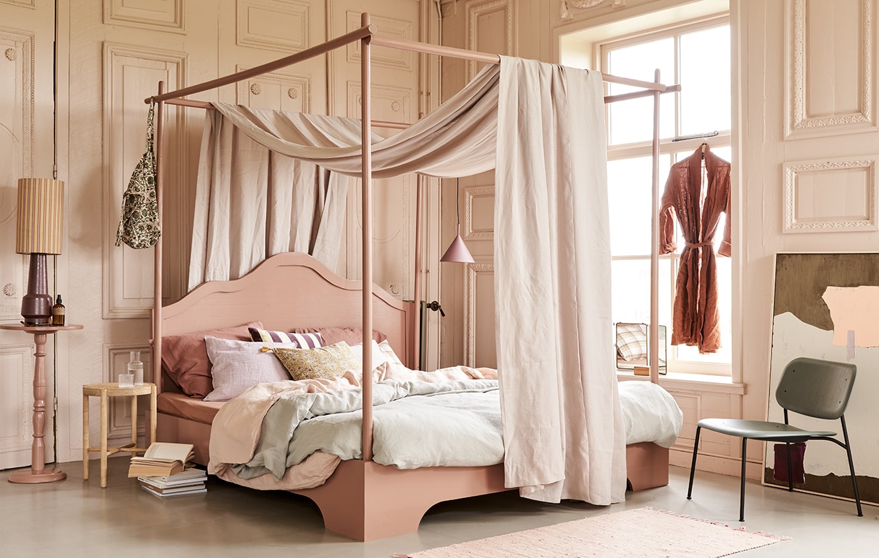 Bed, op maat gemaakt en geschilderd in kleur 86DI64 van D’Imago,180×210 cm prijs op aanvraag, tafeltje op hoge voet geschilderd in kleur 86DI64 van D’Imago, 75 cm (). Hemel Glenmoye van linnen in kleur Nougat van Designers Guild (wva.nl). Dekbedovertrekset van gewassen linnen in kleur Misty Green, 240×220 cm, dekbedovertrekset in Dusty Rose, 240×220 cm, kussenslopen in Clay Rose, 50×60 cm (yumeko.nl). Lampenkap Doris van HKliving, lampvoet, artwork, 100×120 cm, hanglamp mat paars, velvet kussen met paars-gele strepen, houten krukje met webbing zitting (hkliving.nl). Tas met print, linnen kussen Lilac Rose, kussen met bloemenprint in geel Lily Masala, roze vloerkleed Chindi Mat Rose, 60×90 cm (scandicliving.nl). Kussen met ruitprint, roomspray, karaf met glas van Ferm Living (letoile.store). Spiegel (jolandelijkdewebshop.nl). Fauteuil in groen Soft Edge 10 (vtwonen.nl). vtwonen 05-2021 | styling Marlies Does | fotografie Bart Brussee