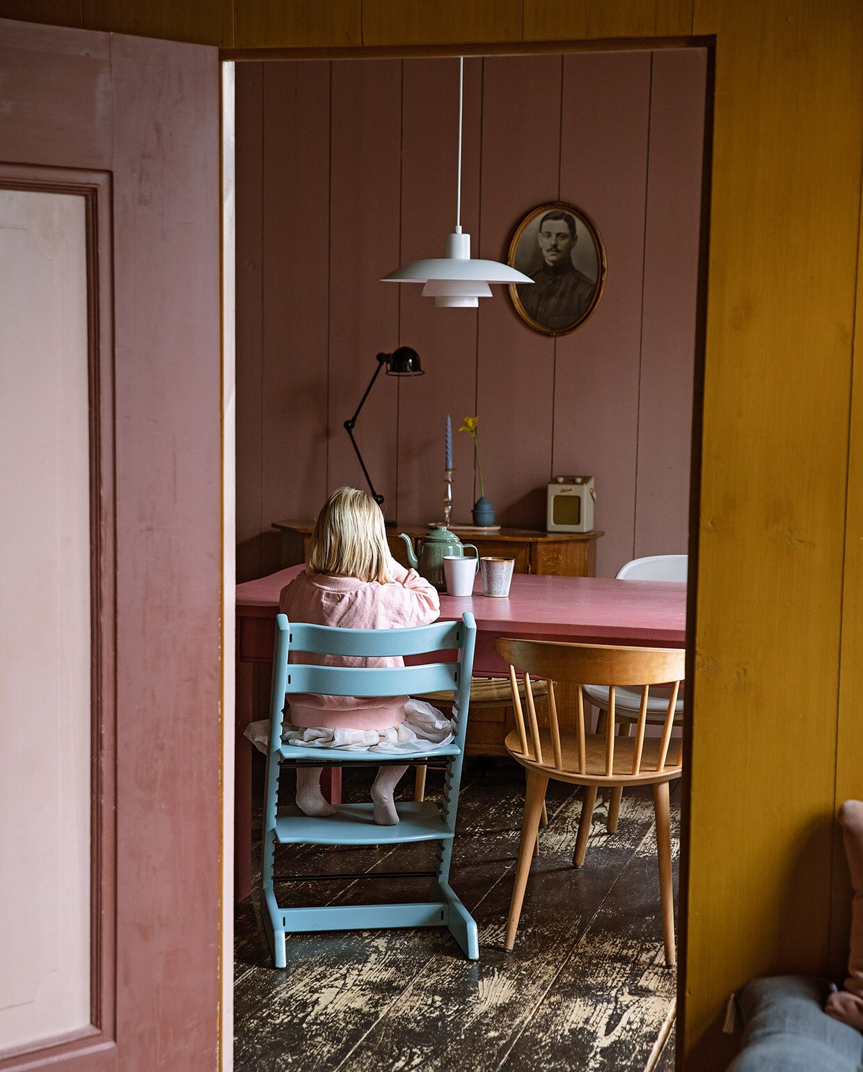 Bureaulamp Jieldé, kandelaar en groene kaars Anna + Nina. Blauwe kaars, tray, witte stoel en houten stoelen Hay. Kinderstoel Stokke. Blauw vaasje Mickey Philips, radio Roberts. Hanglamp Louis Poulsen. Tafel vintage, vaas en kopjes Sissy-Boy, theepot Dille &amp; Kamille. vtwonen 05-2021 | Productie en Styling Ilona Jongepier | Fotografie Dana van Leeuwen
